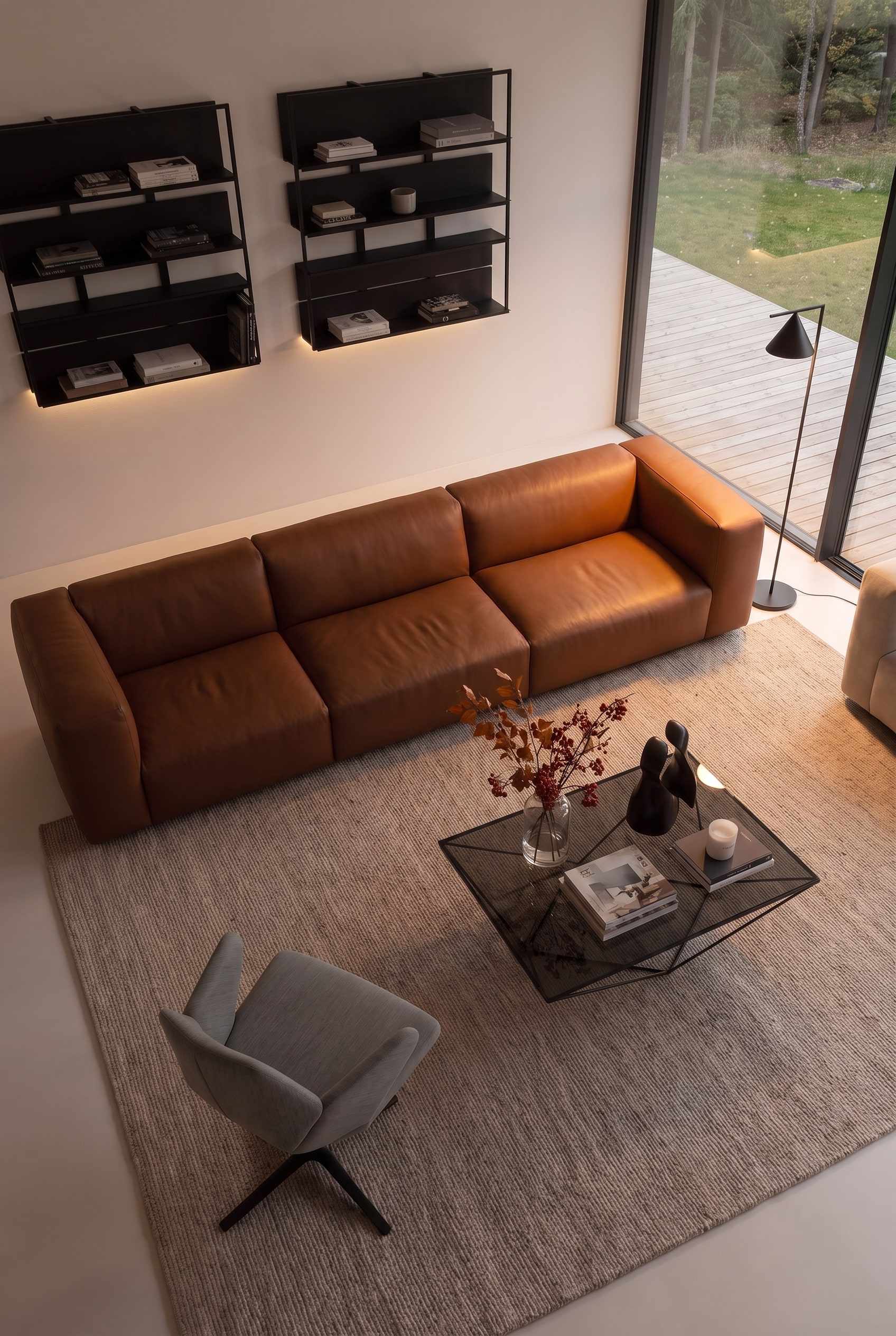 Vogelperspektive auf ein Wohnzimmer mit elegantem Sofa, Sesseln und Couchtisch in perfektem Abstand zueinander.