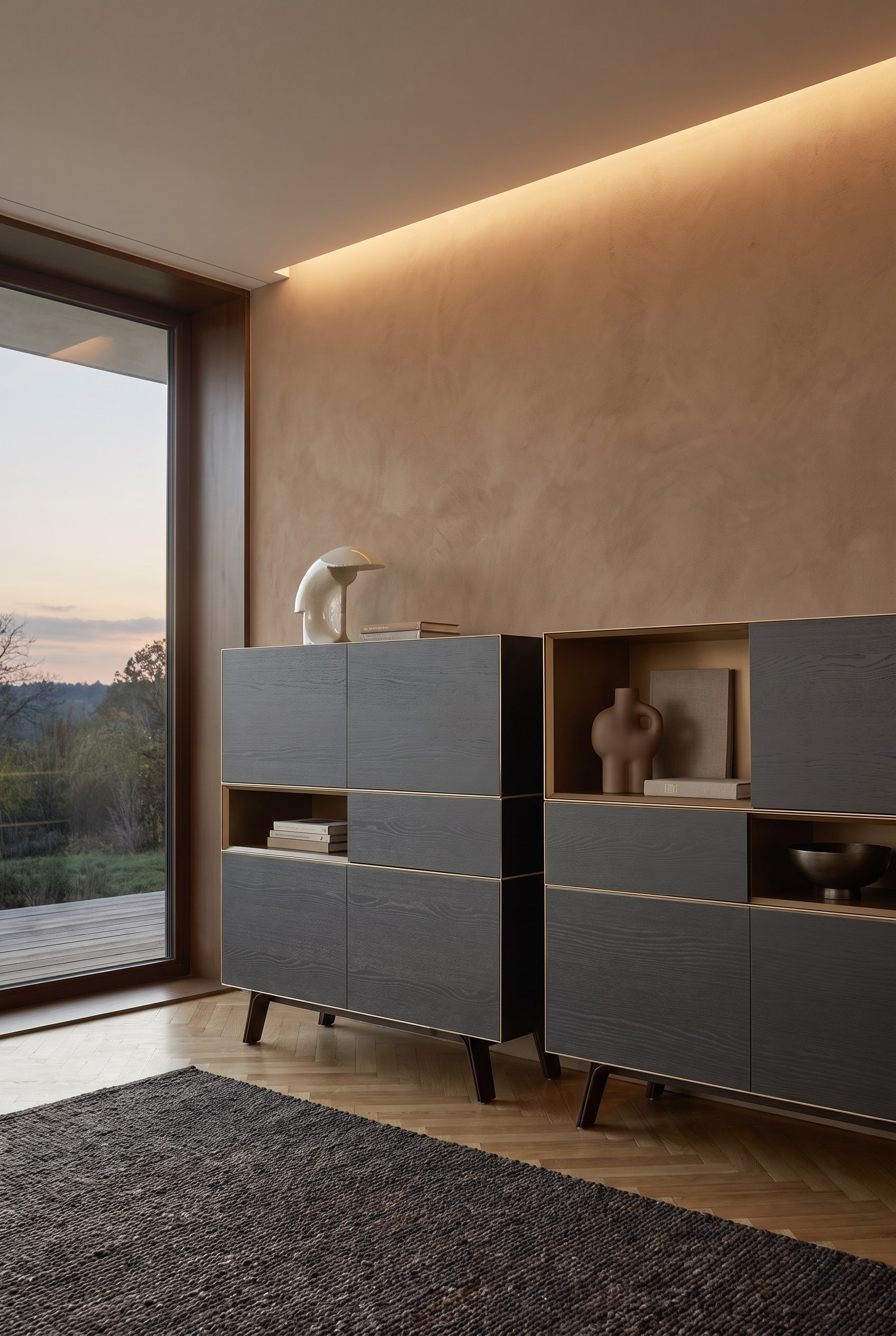 Dunkles Highboard aus Asche-Holz mit Messing-Nische, darauf ein Ton-in-Ton Arrangement aus brauner Keramik, taupefarbenem Leinenbuch und Bronzeschale