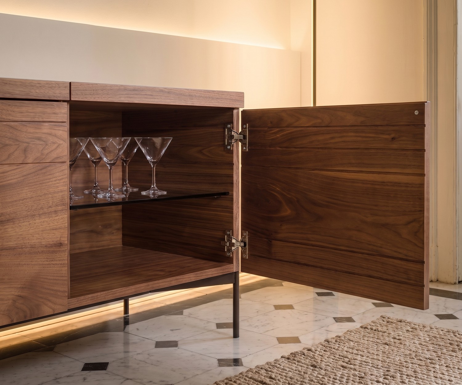 al2 o-rizon 003 designer walnut sideboard al2 o-rizon 003 walnut sideboard, open door showing martini glasses on a glass shelf in a modern home