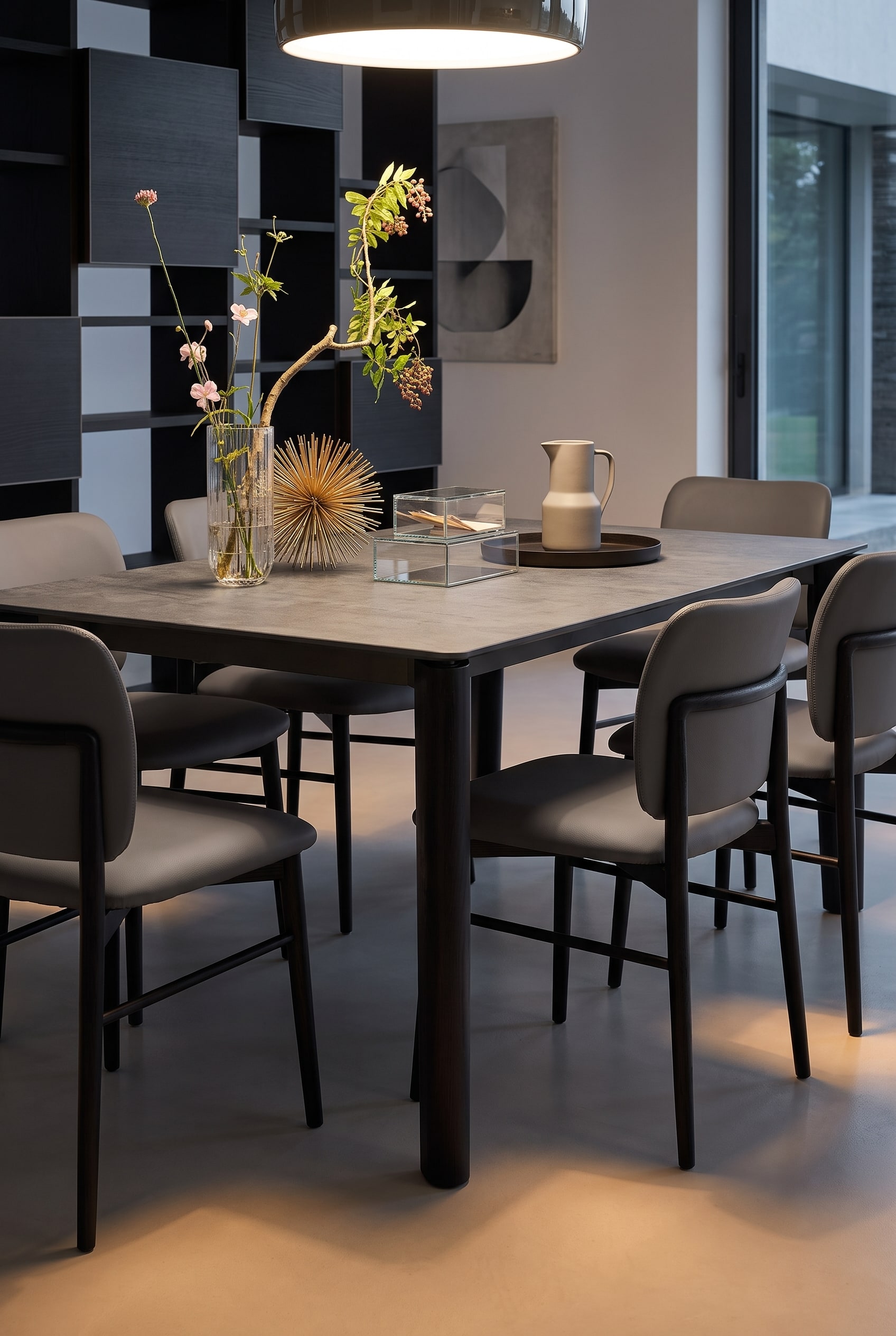 Modern open woonconcept met uitschuifbare houten eettafel en gestoffeerde eetkamerstoelen in donker leer