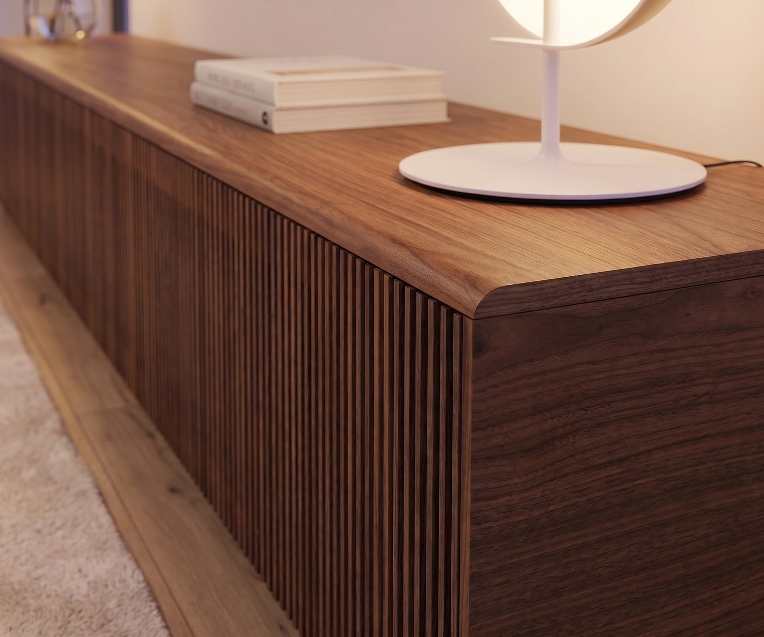 Punt Malmö TV lowboard in dark walnut with slatted front design, shown in a modern living room below a wall TV.