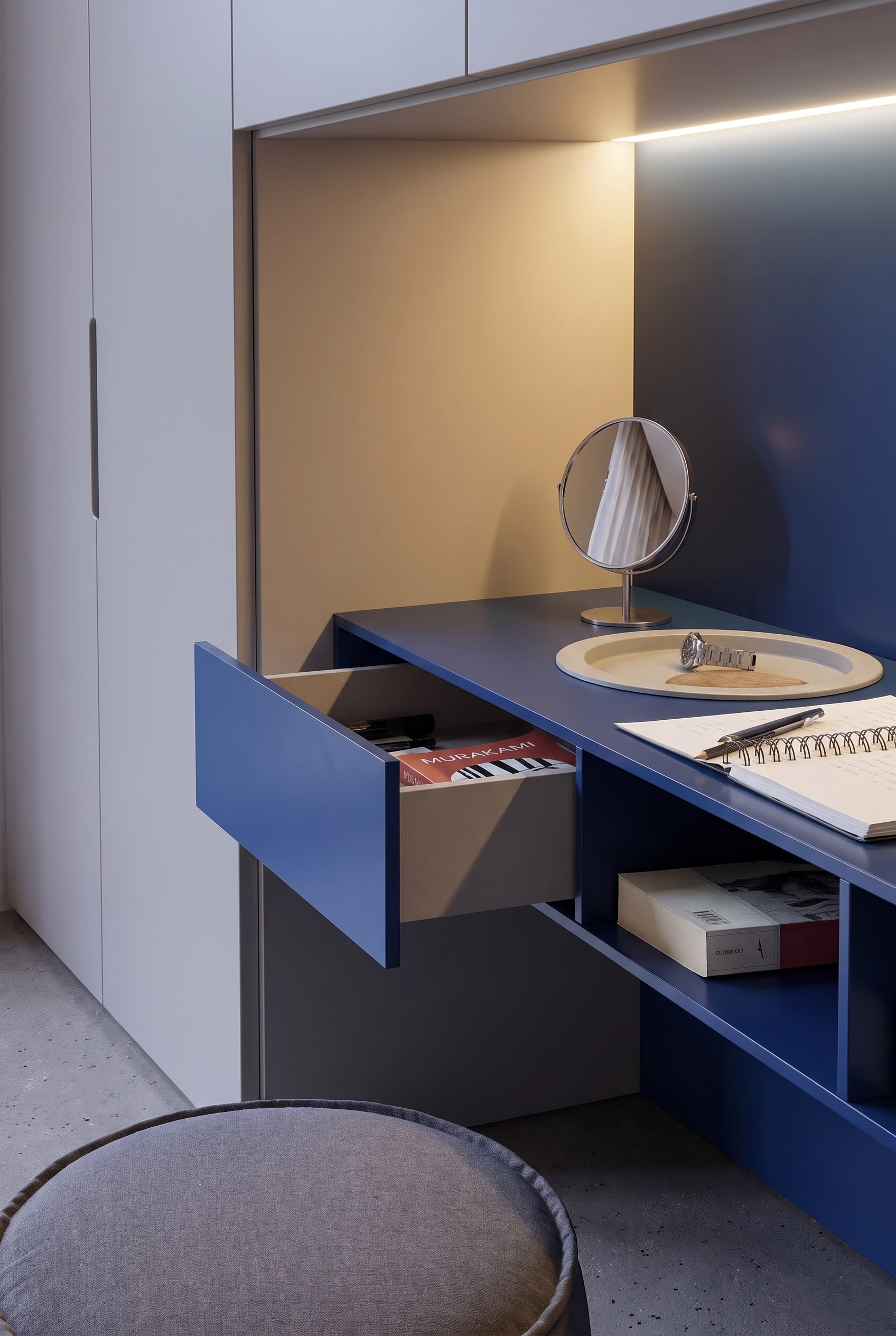 Geopende blauwe lade van de make-uptafel met boeken, daarnaast een open opbergvak onder het tafelblad.