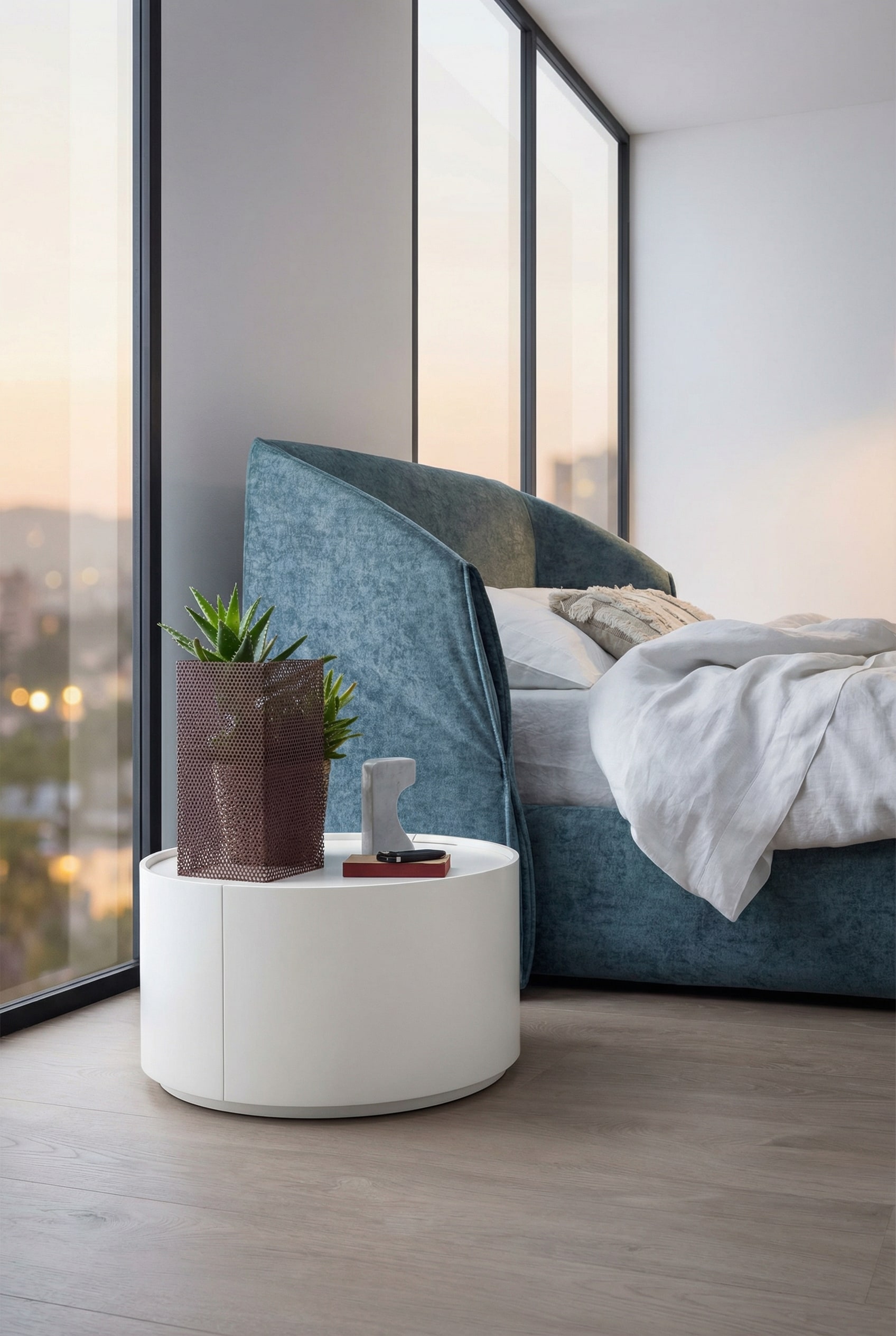 Cylindrical Novamobili Allout side table in white next to a modern bed Cylindrical Novamobili Allout side table in white next to a modern bed