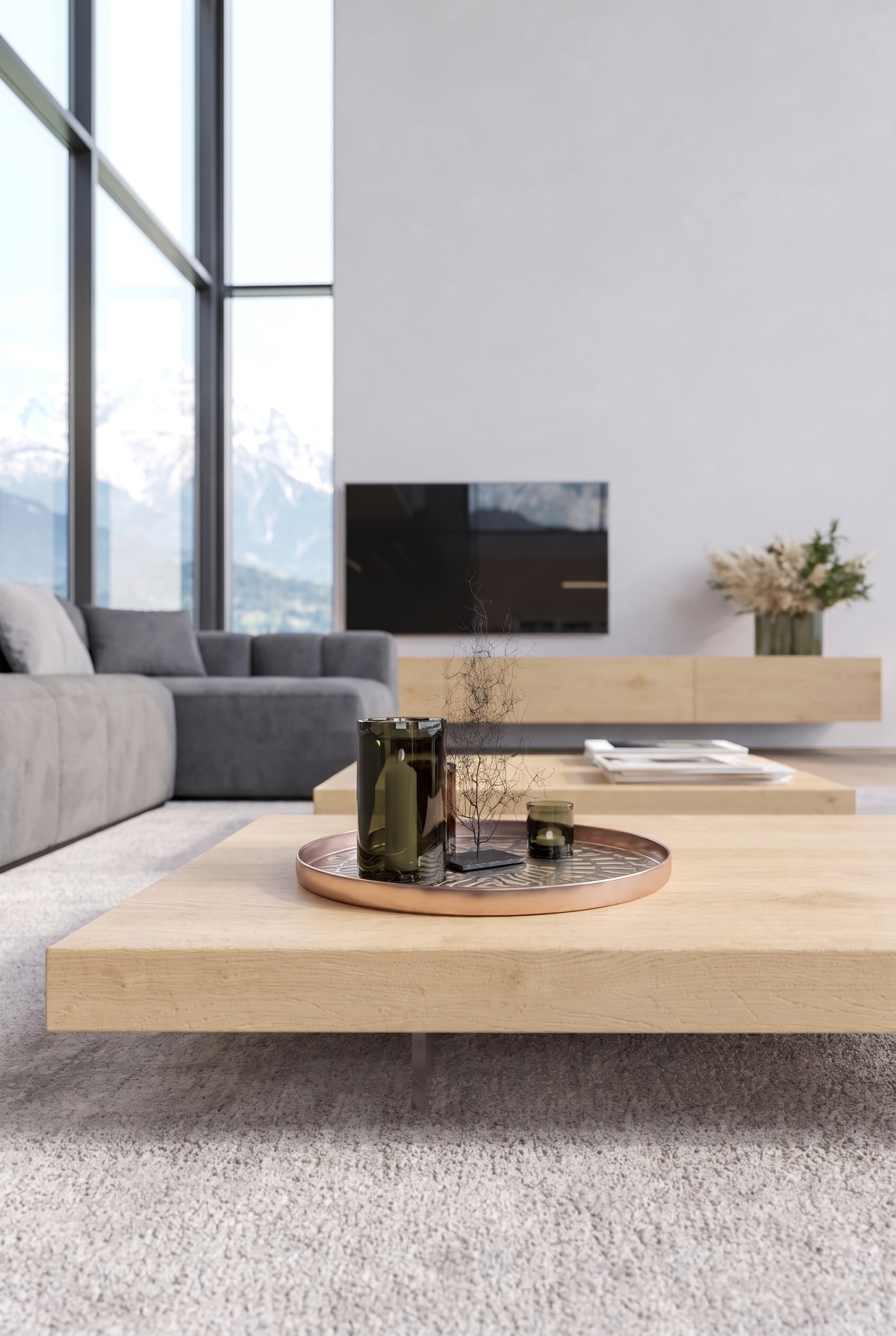 Minimalistische woonkamer met zeer lage eikenhouten salontafel, daarop alleen een donkergroene glazen vaas en een koperen dienblad