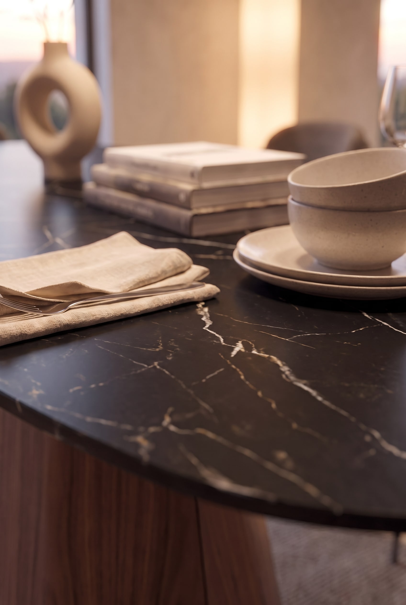 Close-up van het zwarte Marquina-keramiekblad met opvallende witte adering en licht servies.