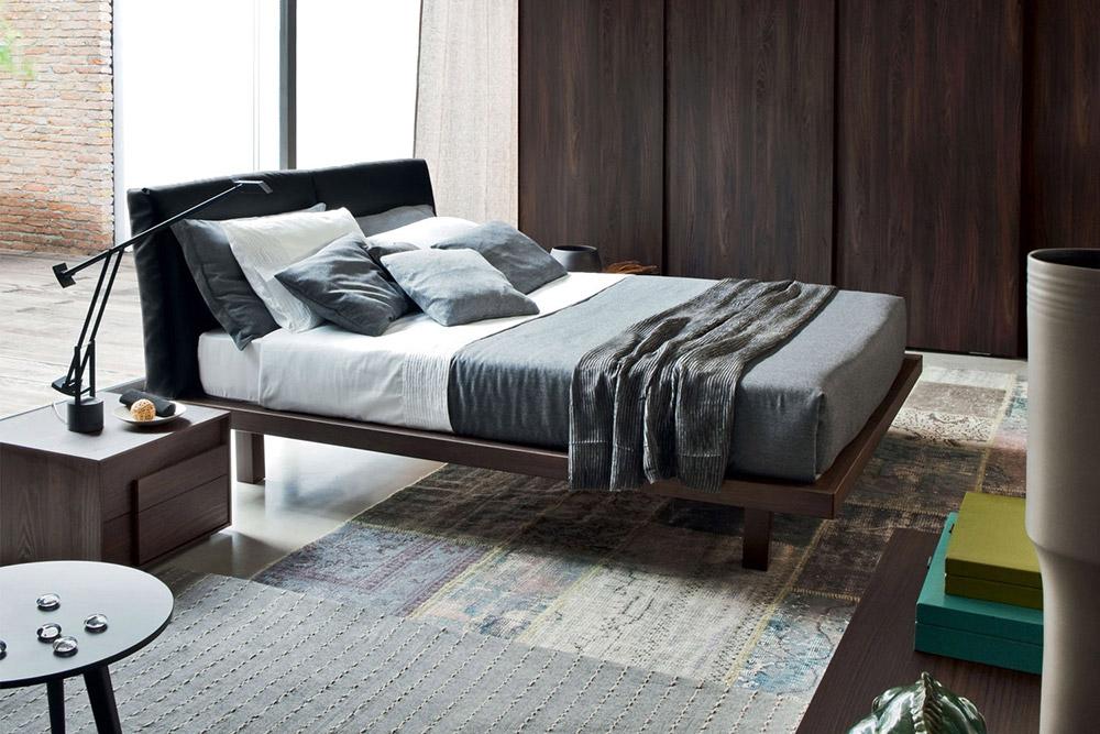 Das Novamobili Bett Nido hat einen Holzrahmen und ein gepolstertes Kopfteil aus schwarzen Echtleder.