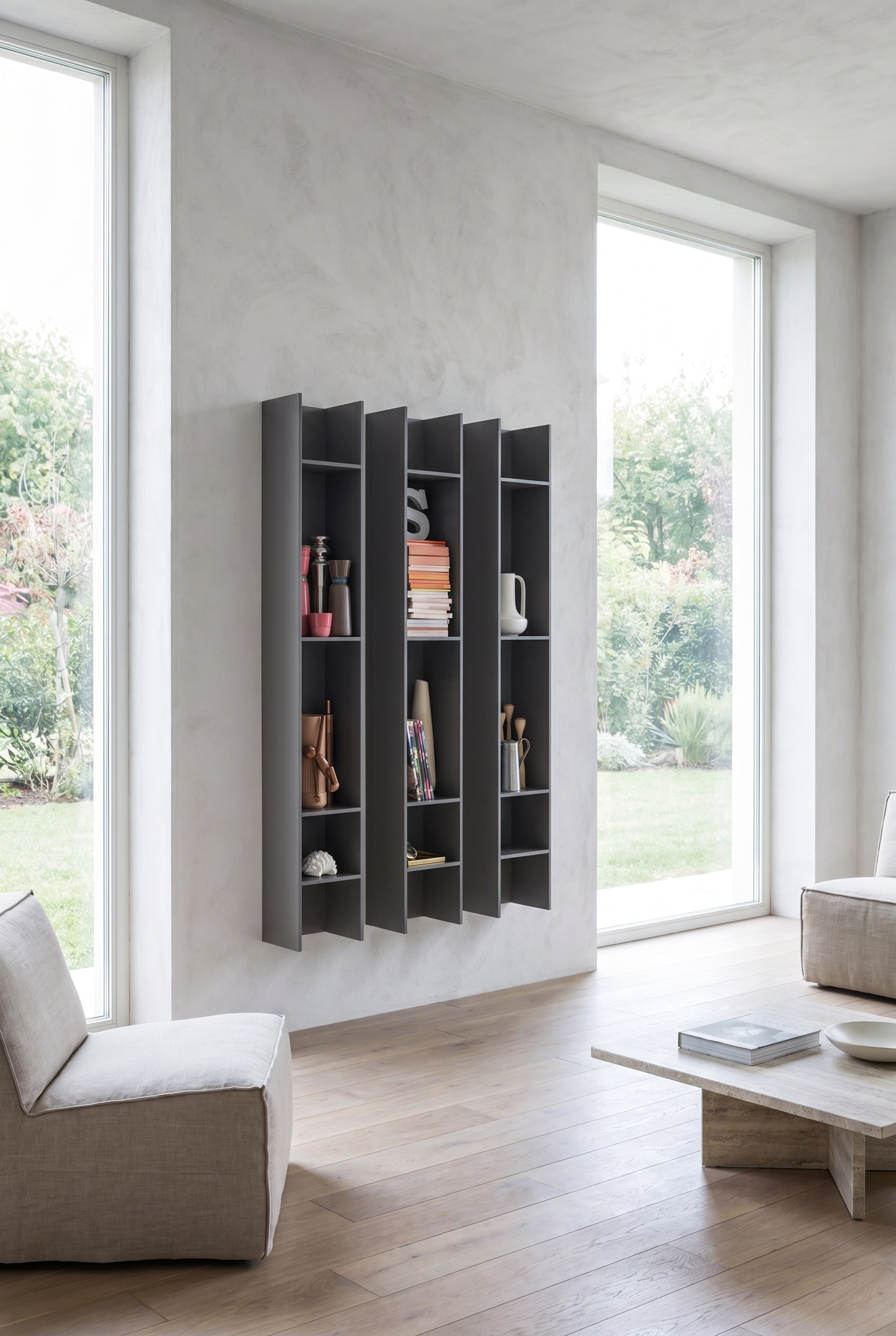 Elegante woonkamer met twee smalle, staande Novamobili wandboekenrekken Butterfly in antraciet, asymmetrisch geplaatst naast een grote raampartij