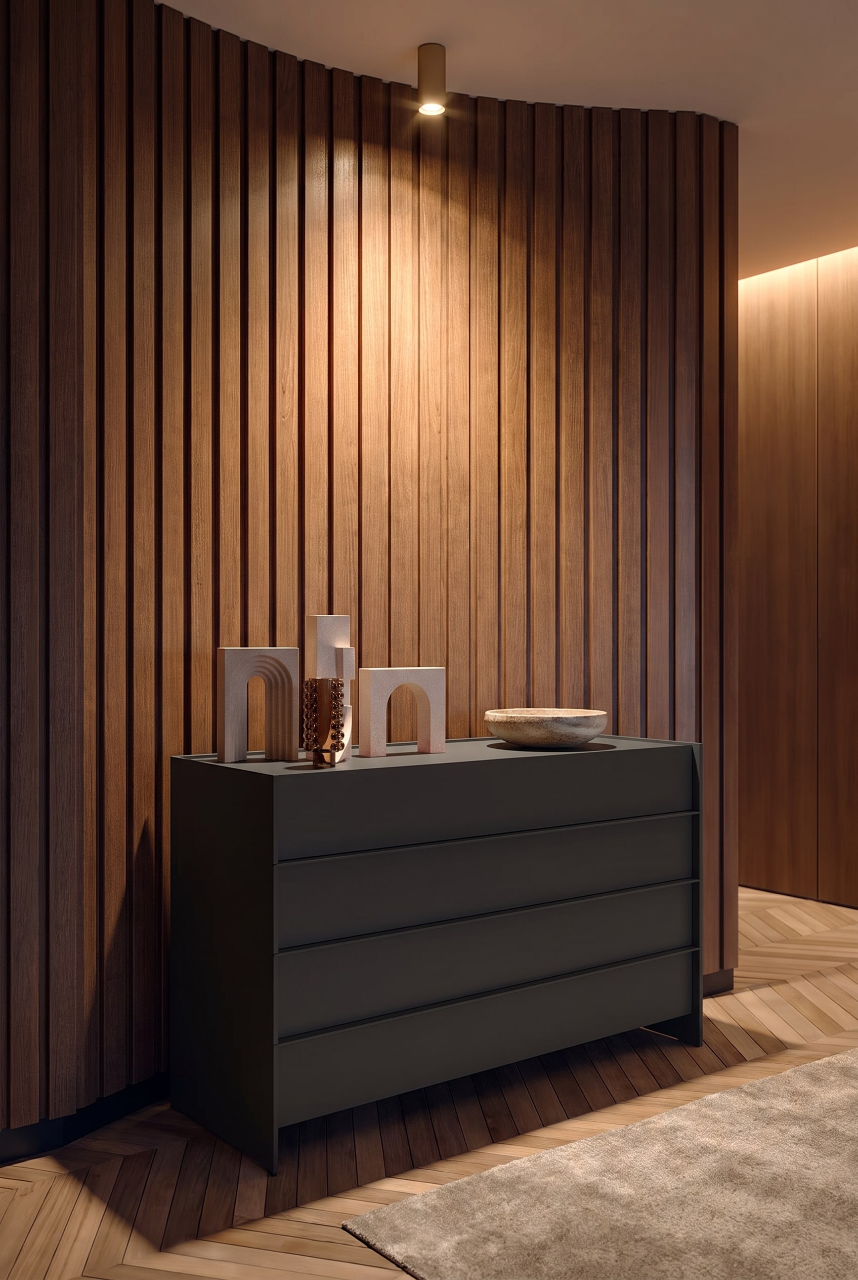 Cassettiera con fresatura a scanalature nell'ingresso, illuminata da un faretto a soffitto, con una ciotola in ceramica sopra