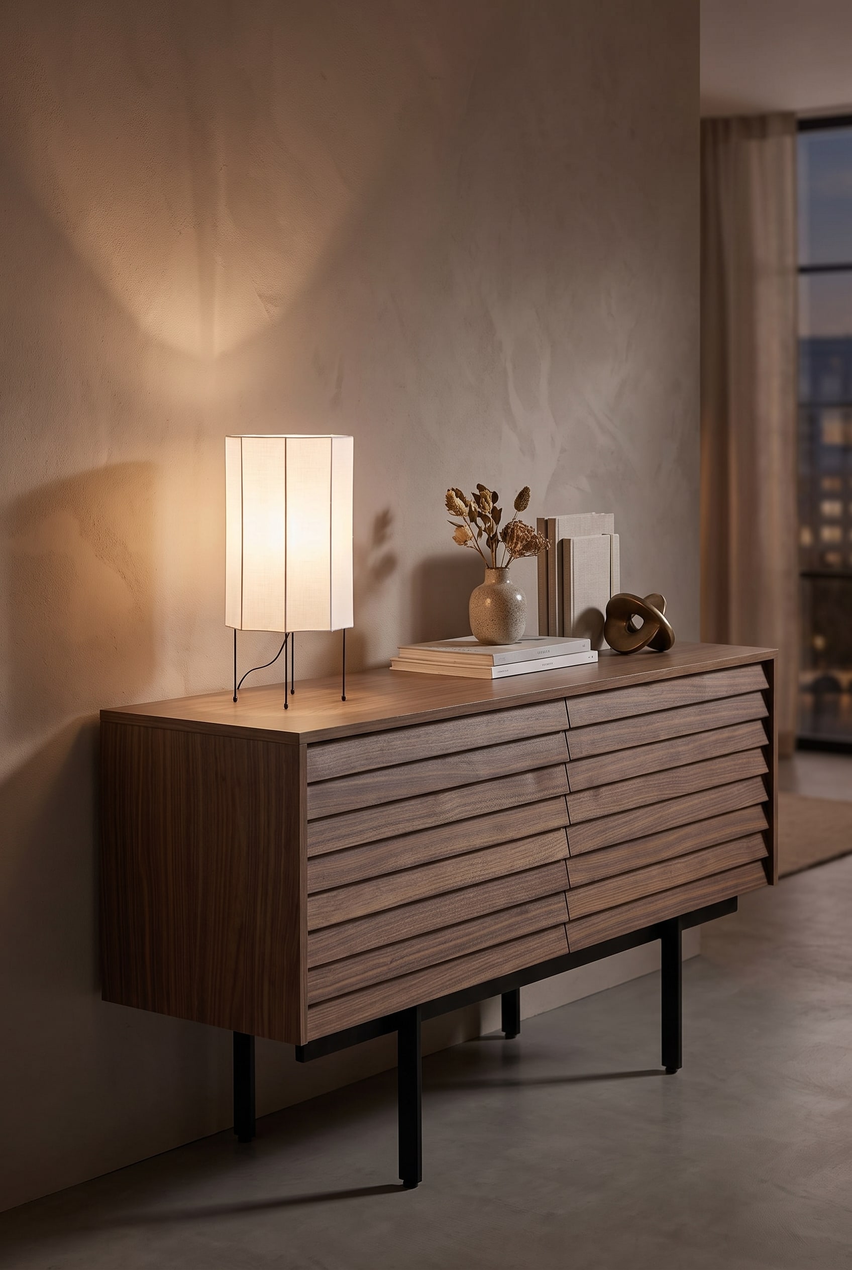 Detailed shot of a puristic table lamp with a light textile shade on a dark walnut console in warm light