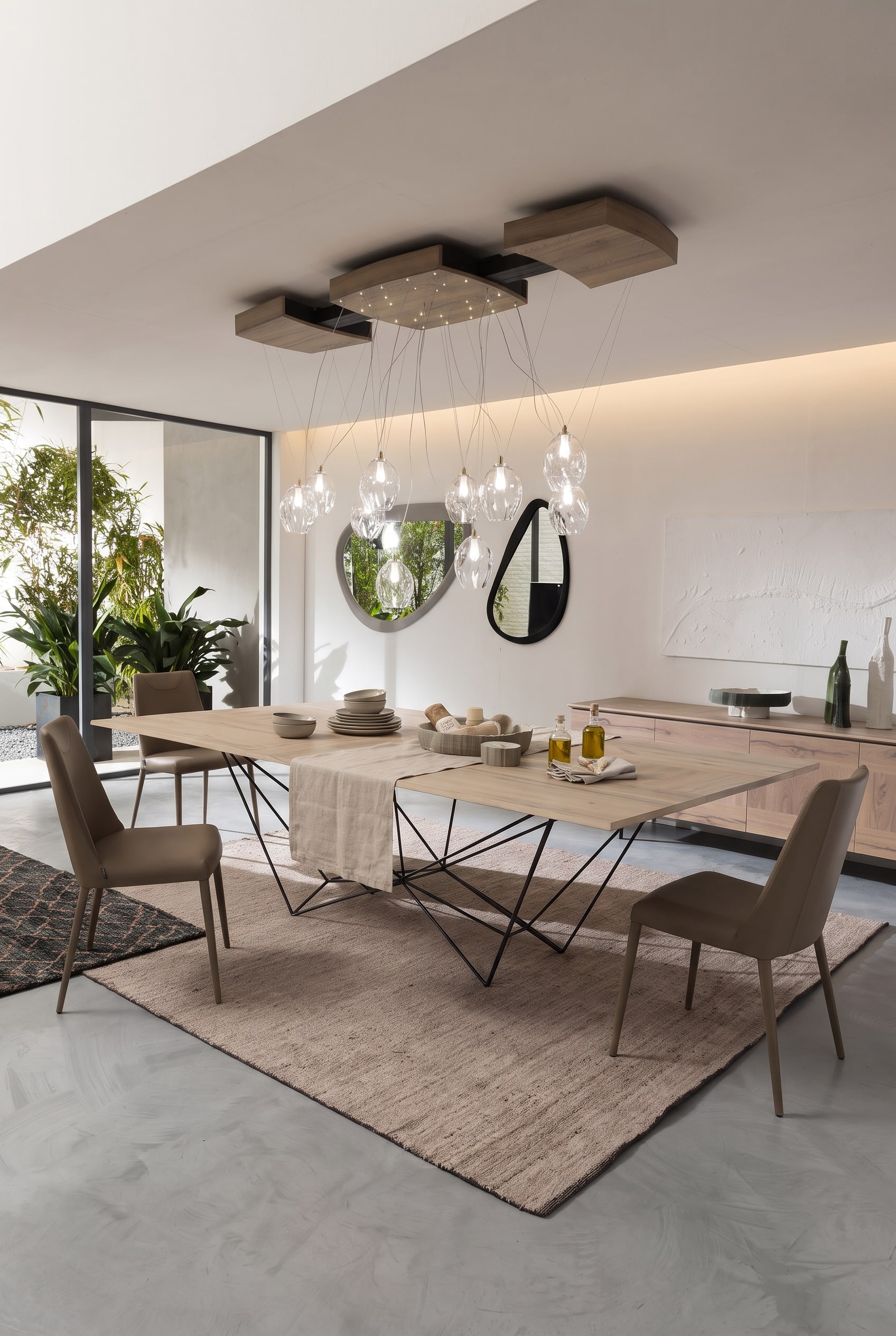 Modern dining room with extendable wooden table, black metal frame, and elegant leather chairs