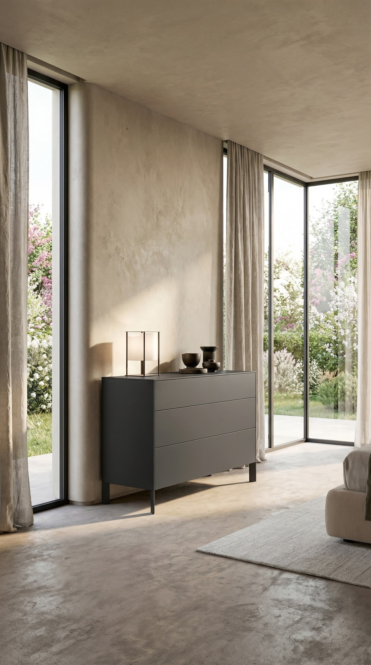 Dunkelgraue minimalistische Kommode vor beiger Wand mit sanftem Frühlingslicht Dunkelgraue minimalistische Kommode vor beiger Wand mit sanftem Frühlingslicht