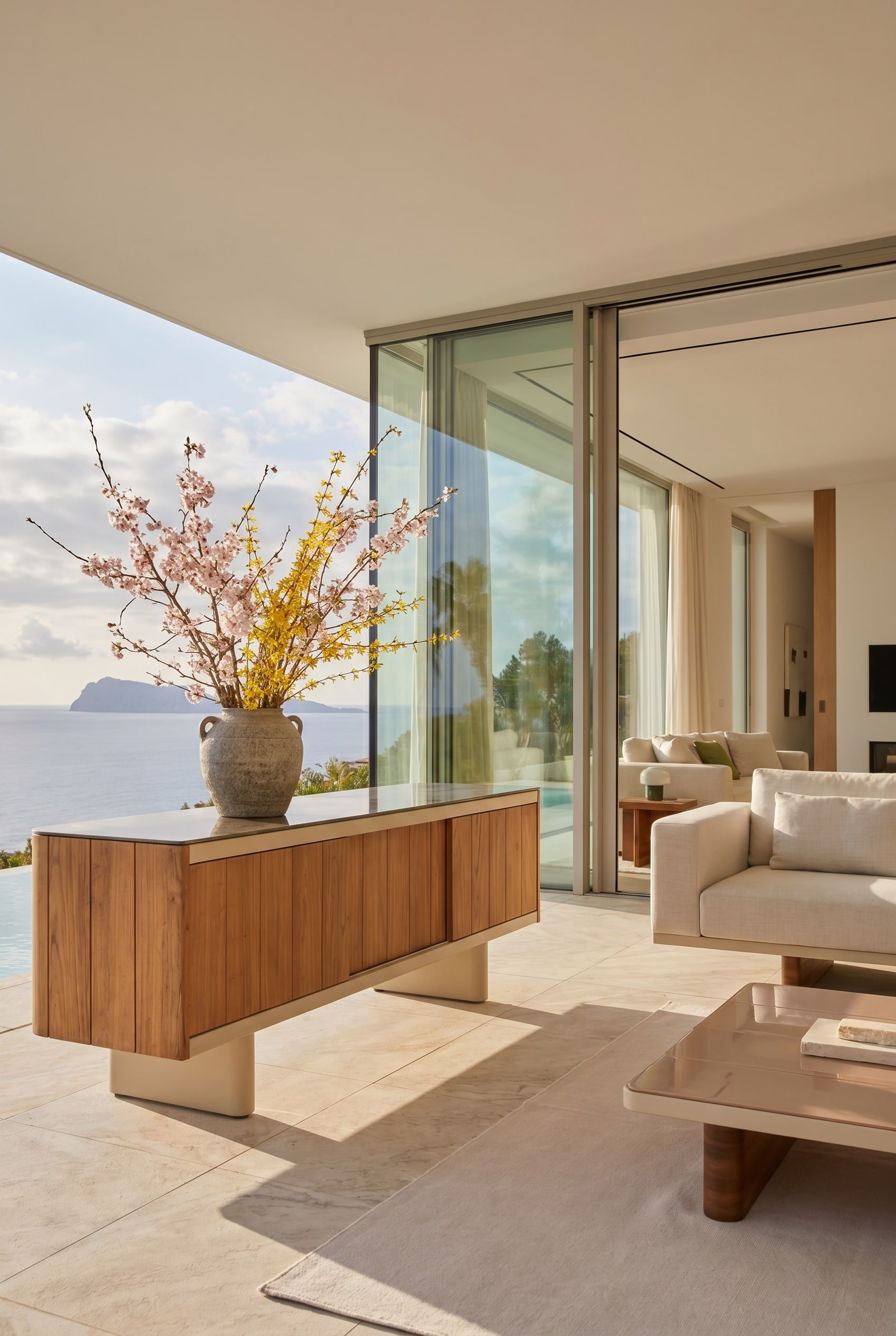 Elegantes Outdoor-Sideboard auf einer Loggia, dekoriert mit einer massiven Steingutvase und Fr&uuml;hlingszweigen