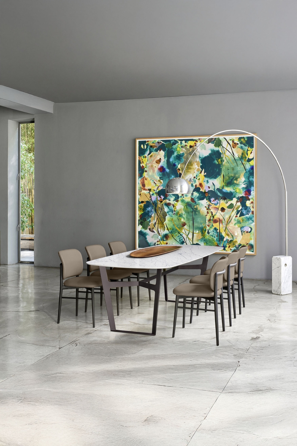 grosses-gefliestes-esszimmer-mit-einer-minimalistisch-designten-esstischgruppe-und-bogenlampe-vor-einem-farbenfrohen-abstrakten-wandbild