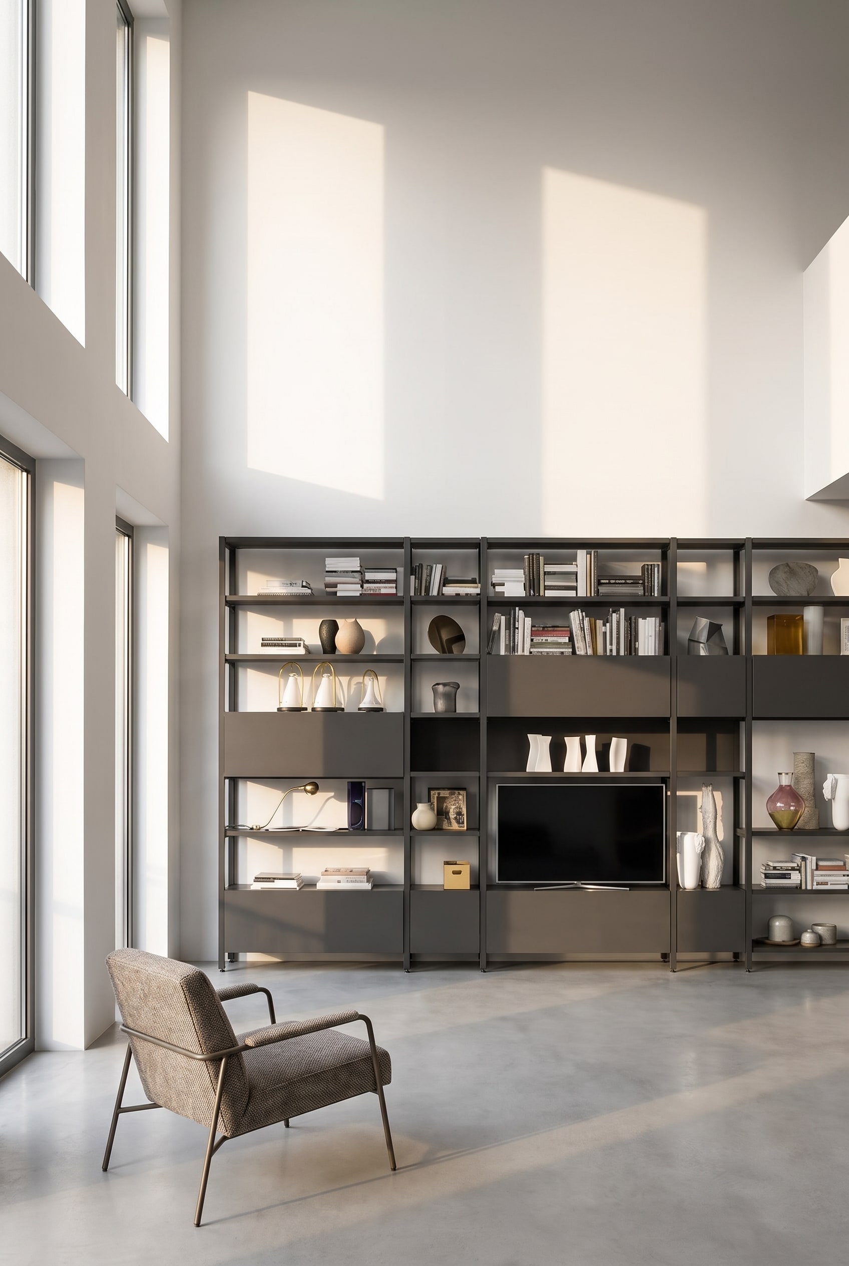 Modern filigree metal shelf in a dark finish against a white wall in an old building, sparsely decorated with vases and books