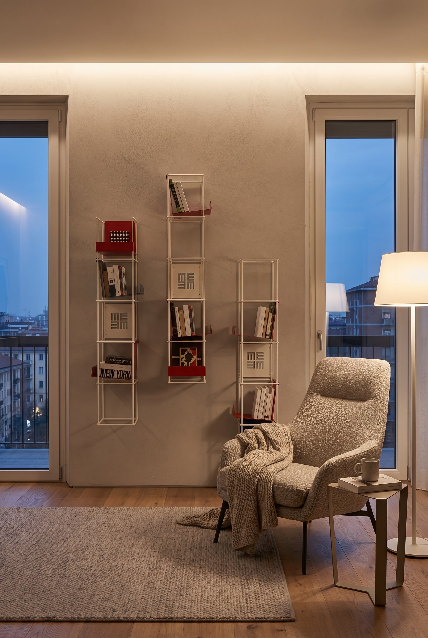 Nicchia stretta nel soggiorno con libreria a muro verticale in metallo e libri