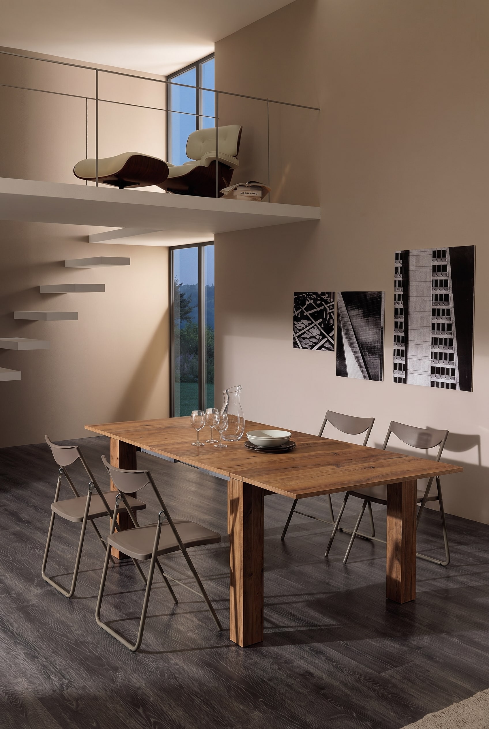 Modern studio-appartement met een tot een lange eettafel uitgeschoven houten console en minimalistische klapstoelen