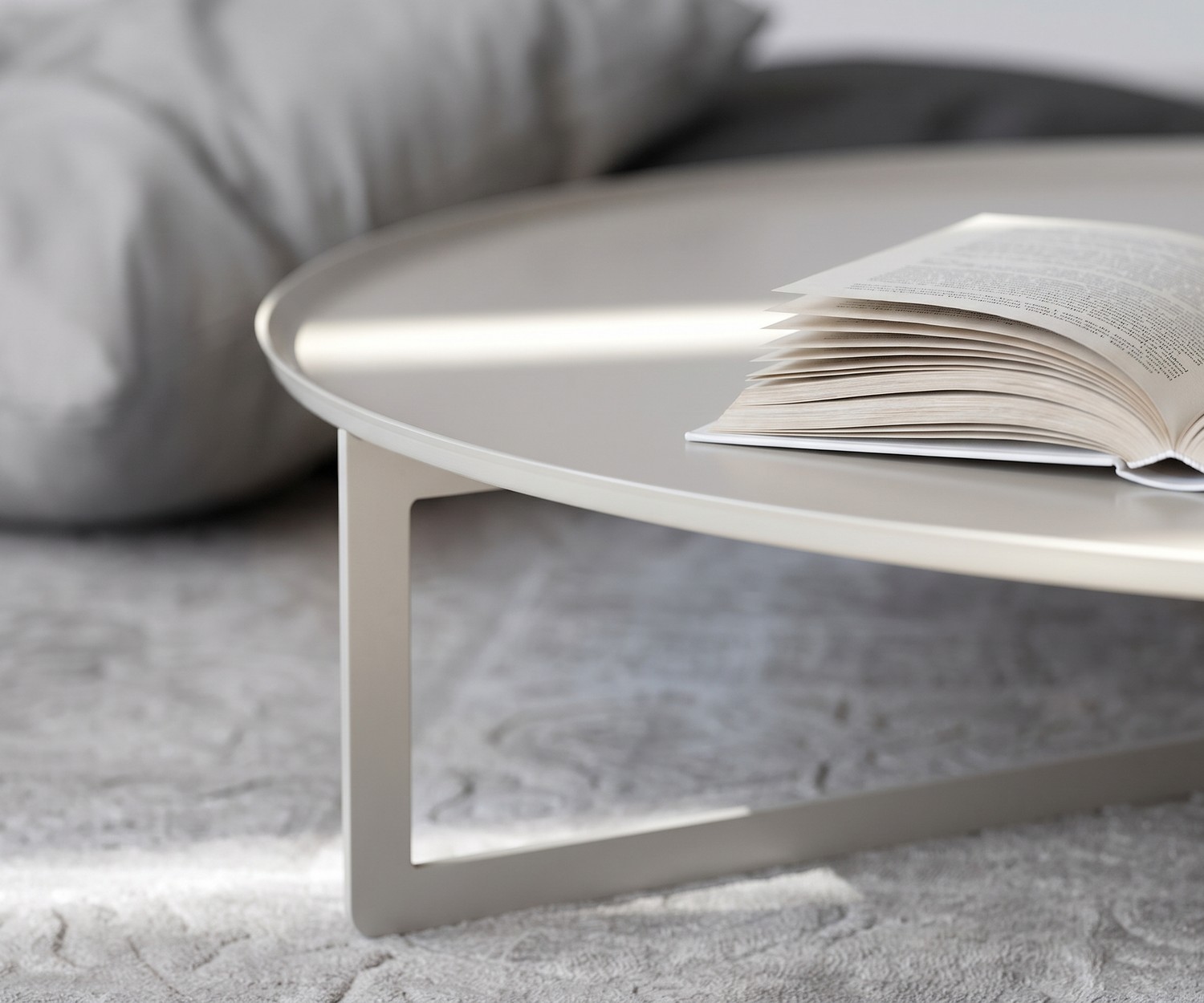 Round Couchtisch von MEME Design im modernen Wohnzimmer. Runder flacher Design-Metalltisch neben beigem Sofa.