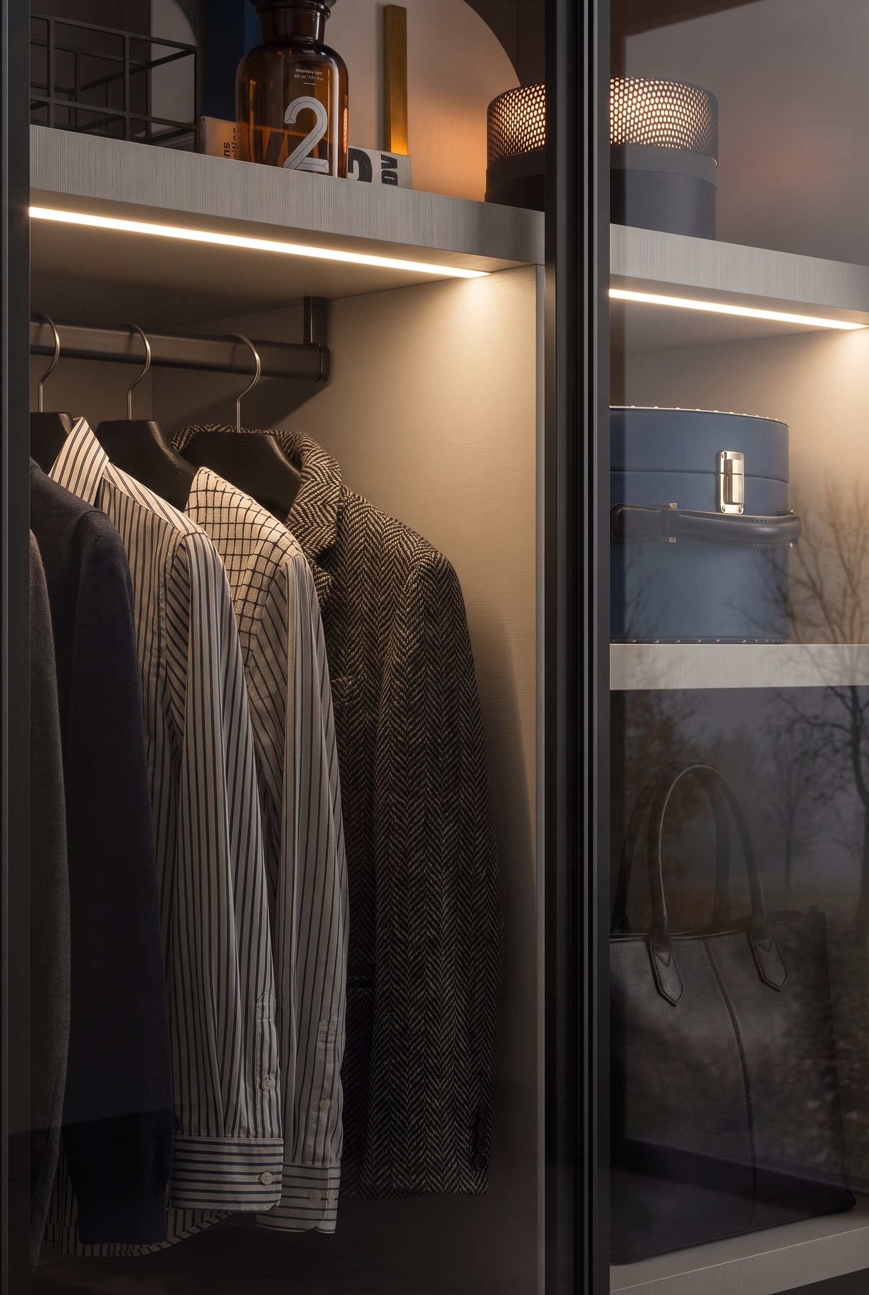 Armadio di alta qualità con frontali in vetro fumé, dove l'illuminazione interna indiretta e i ripiani stabili creano un'atmosfera da boutique.