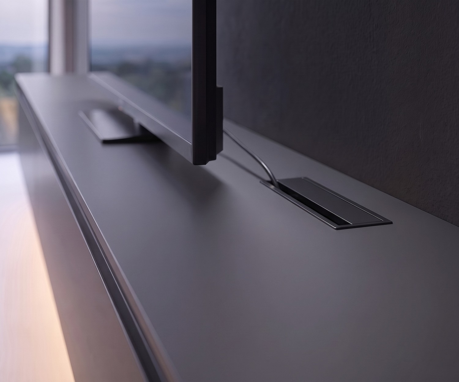 Novamobili Reverse TV lowboard in charcoal grey in a modern living room with wall-mounted TV, rug and coffee table.