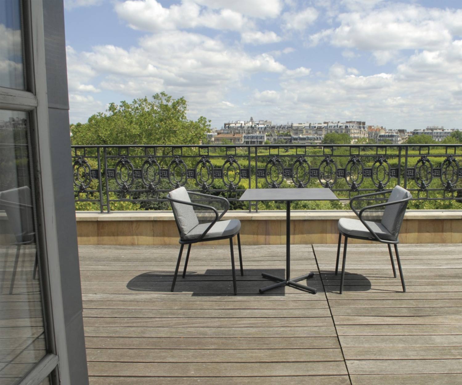 Moderner Todus Condor Design Bistrotisch mit Gartenstühlen auf einer Terrasse Moderner Todus Condor Design Bistrotisch mit Gartenstühlen auf einer Terrasse