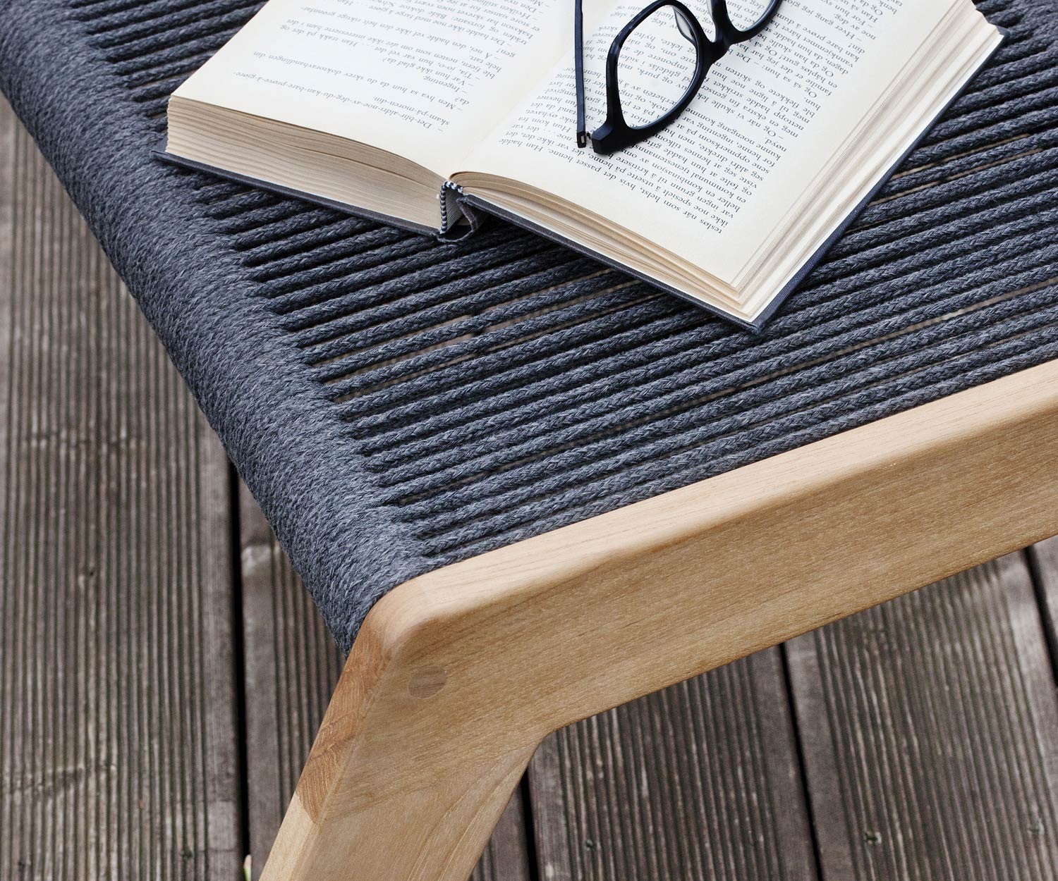 Oasiq Skagen design stool with upholstered cushion in dark grey in front of deckchair