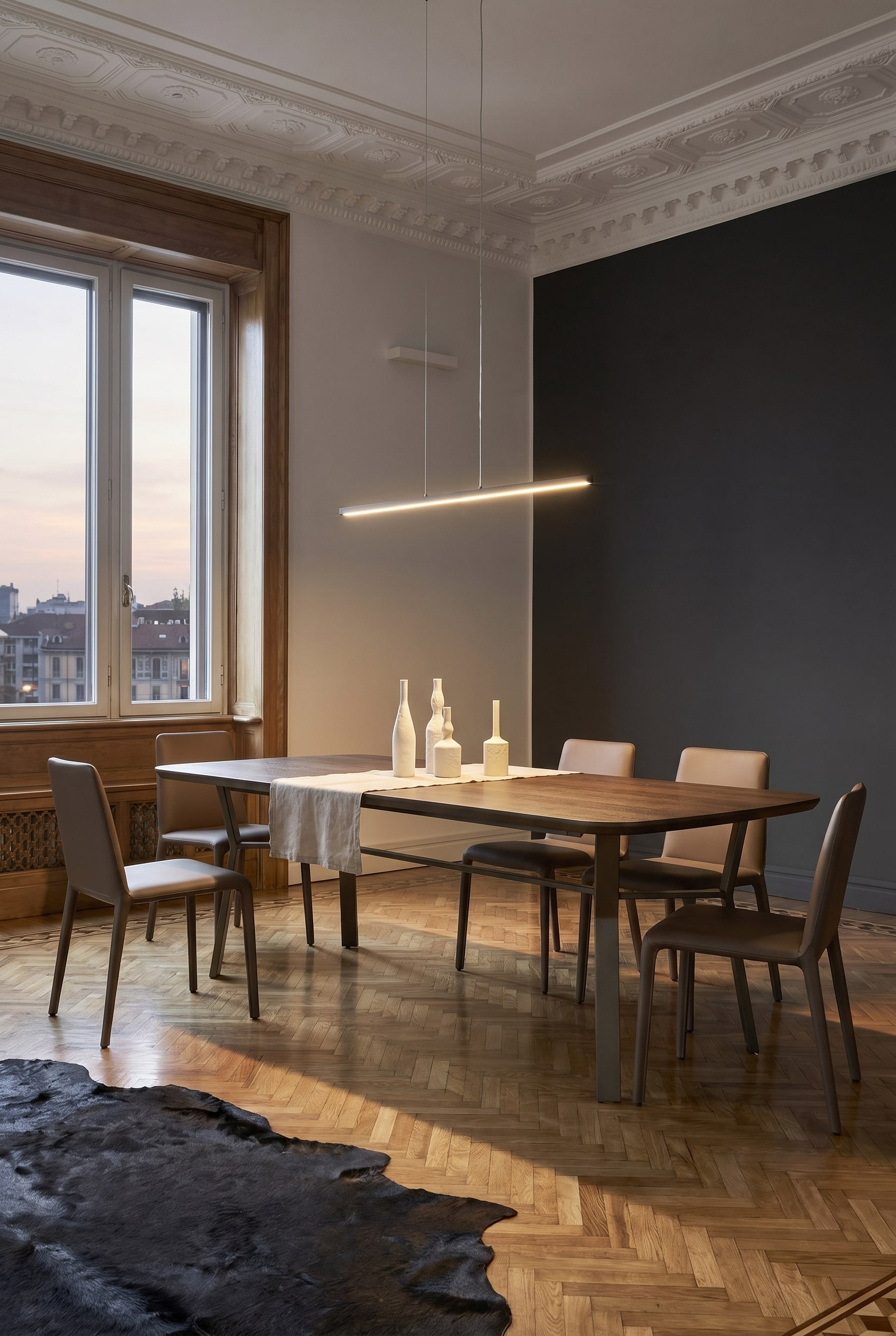 Eetkamer in industri&euml;le chic met strakke eettafel, opvallend donker metalen onderstel en minimalistische stoelen