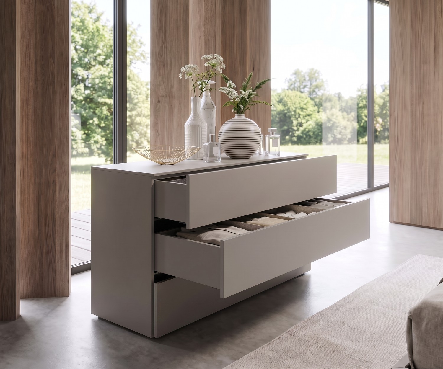 Livitalia Atena Design Kommode in Hellgrau Livitalia Atena Kommode mit Schubladen im Schlafzimmer, hellgrau matt, moderne Dekoration mit Vasen vor Fensterfront.