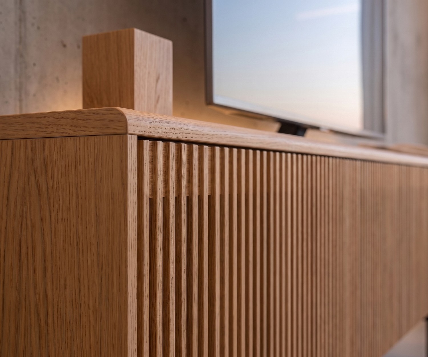 Punt Malmö TV lowboard for living room media storage in natural oak wood featuring stylish vertical slatted front detail.