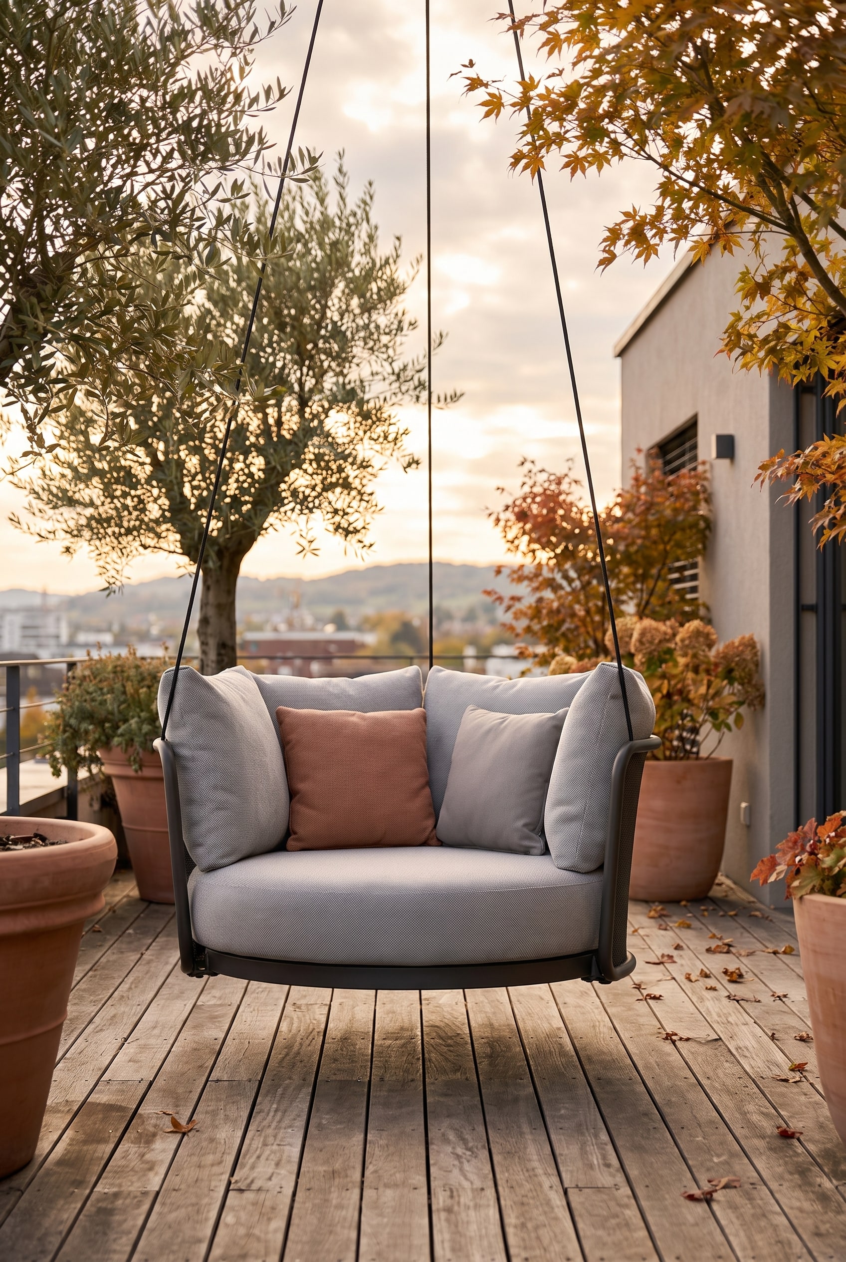 Fauteuil suspendu moderne avec coque d'assise ronde et coussins épais, flottant au-dessus d'une terrasse en bois