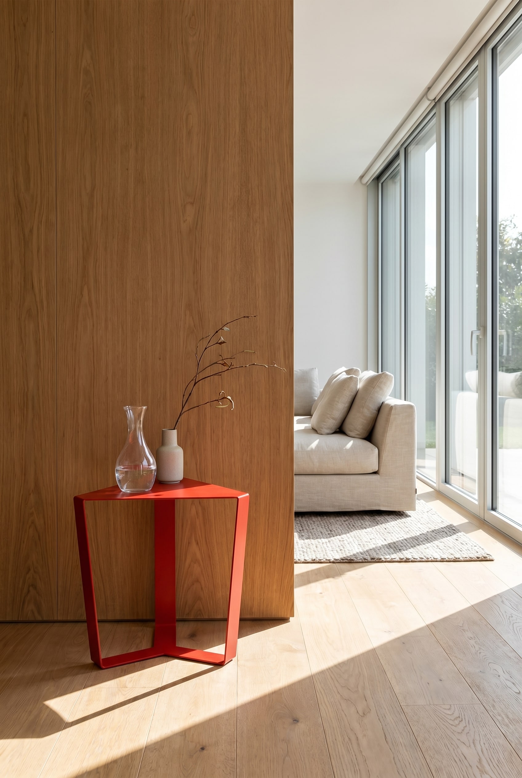 Minimalistische geometrische bijzettafel van dun rood metaal voor een massieve wand met houten panelen