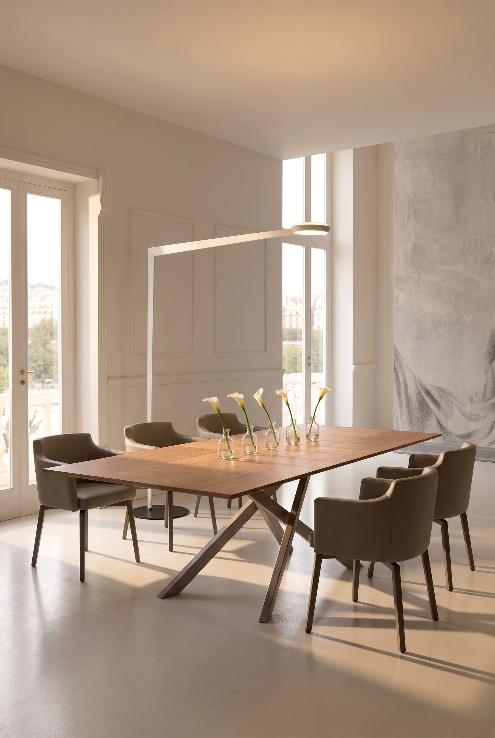 Ruime eetkamer met lange houten eettafel, opgestelde kleine glazen vazen en taupekleurige lederen fauteuils