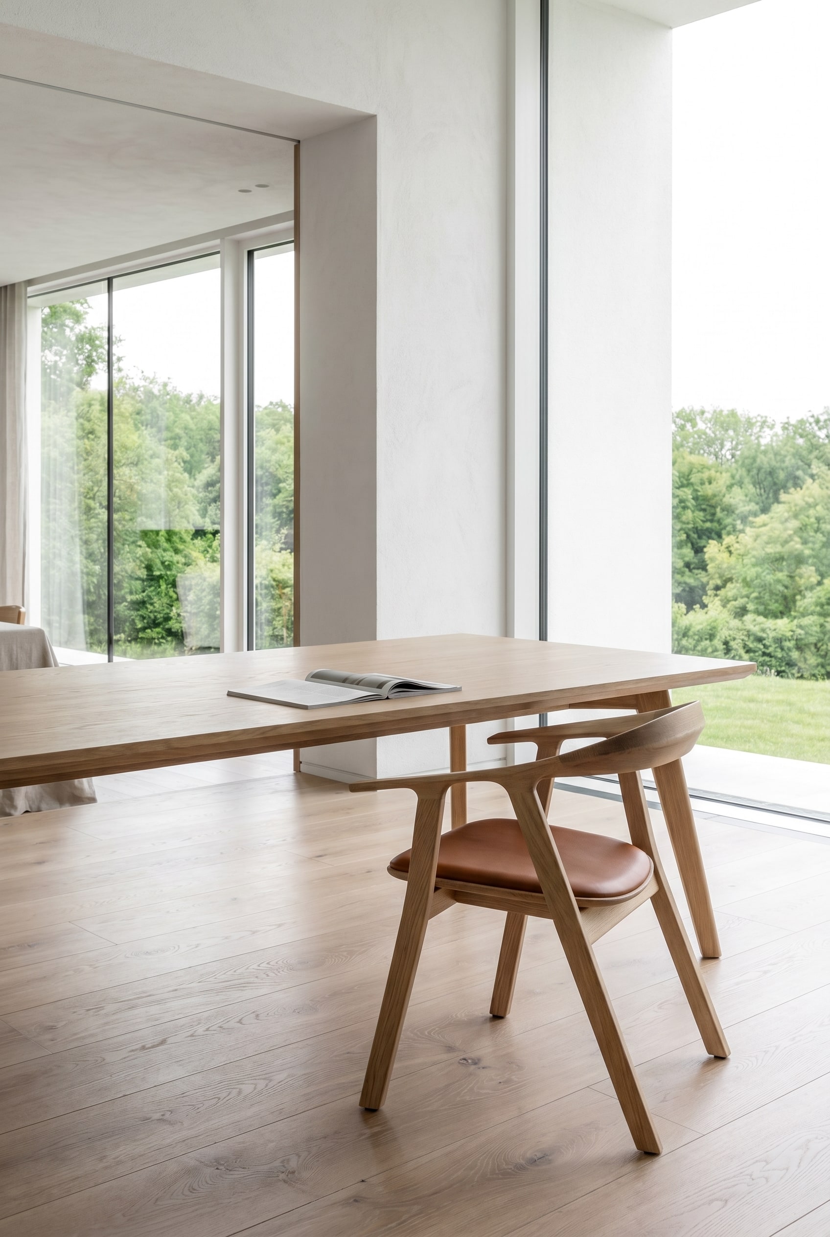 Modern dining room with wooden dining table and Prostoria Rhomb wooden chairs in oak with brown leather upholstery in bright daylight