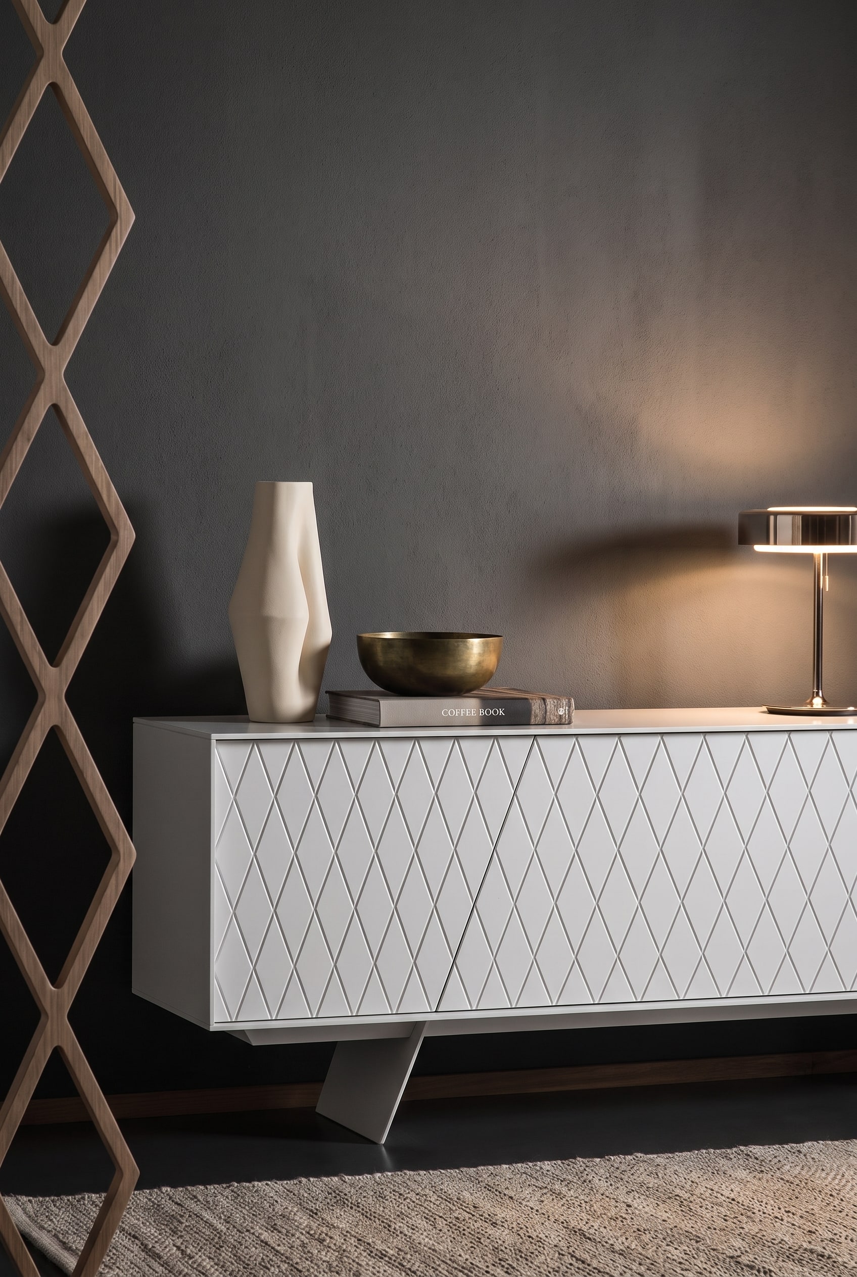 An elegantly decorated al2 e-klipse 003 sideboard, on the left side of which an asymmetrical trio of a ceramic vase, a brass bowl, and a horizontally placed coffee table book is arranged.