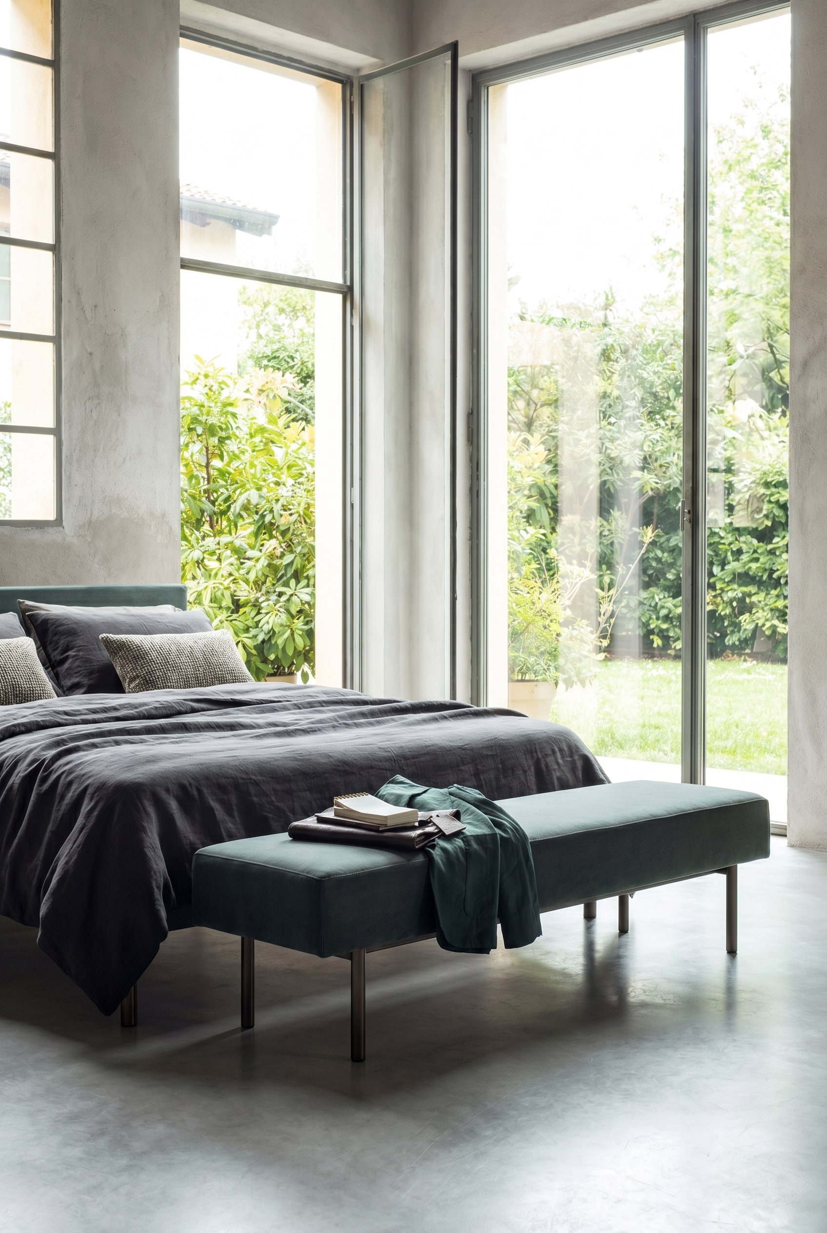 Elegante minimalistische gestoffeerde bank met slanke poten aan het voeteneinde van een moderne slaapkamer Elegante minimalistische gestoffeerde bank met slanke poten aan het voeteneinde van een moderne slaapkamer