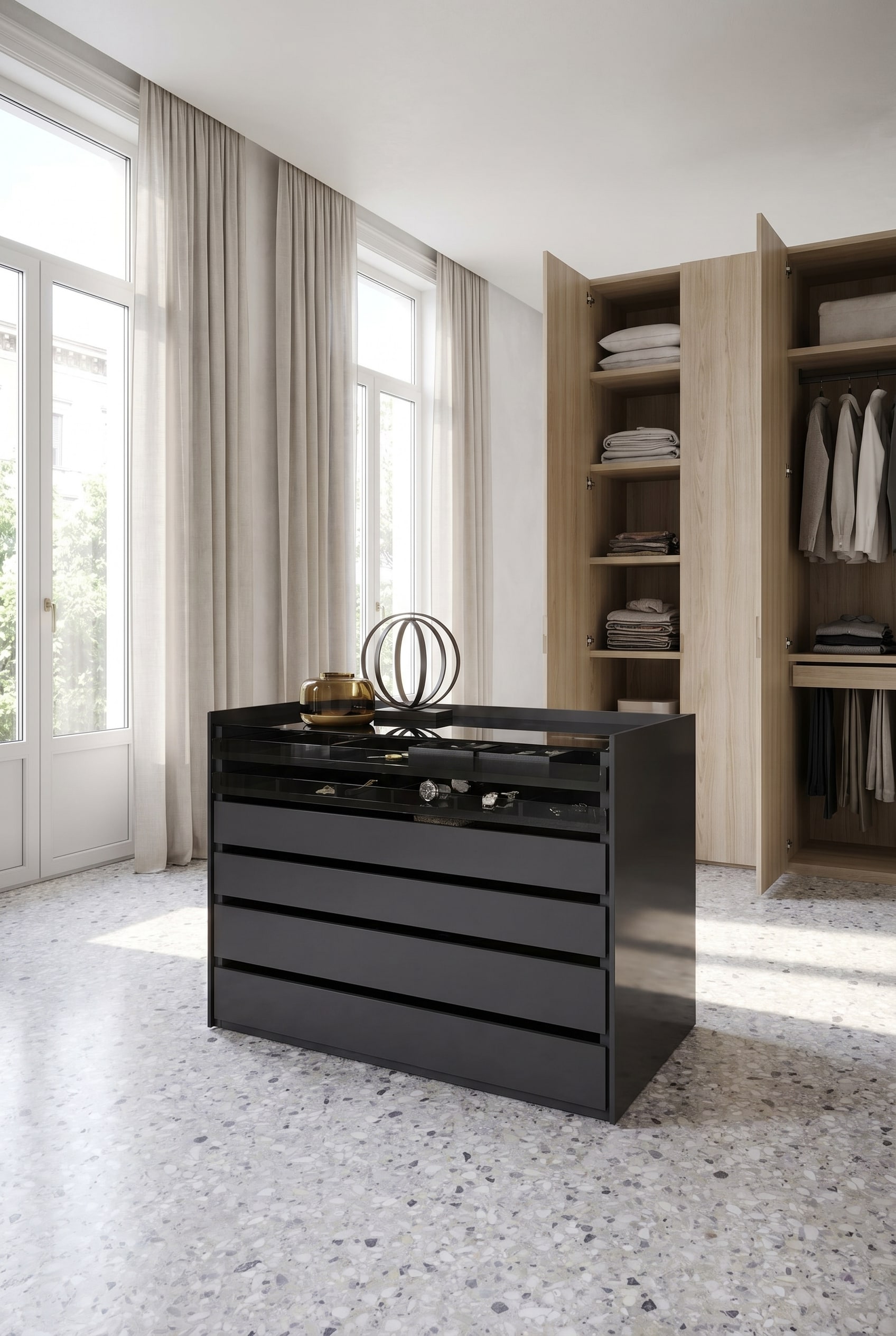 Ruime kleedkamer met een centraal kasteiland in donker lak, een glazen bovenplaat voor accessoires en lichte open kasten op de achtergrond