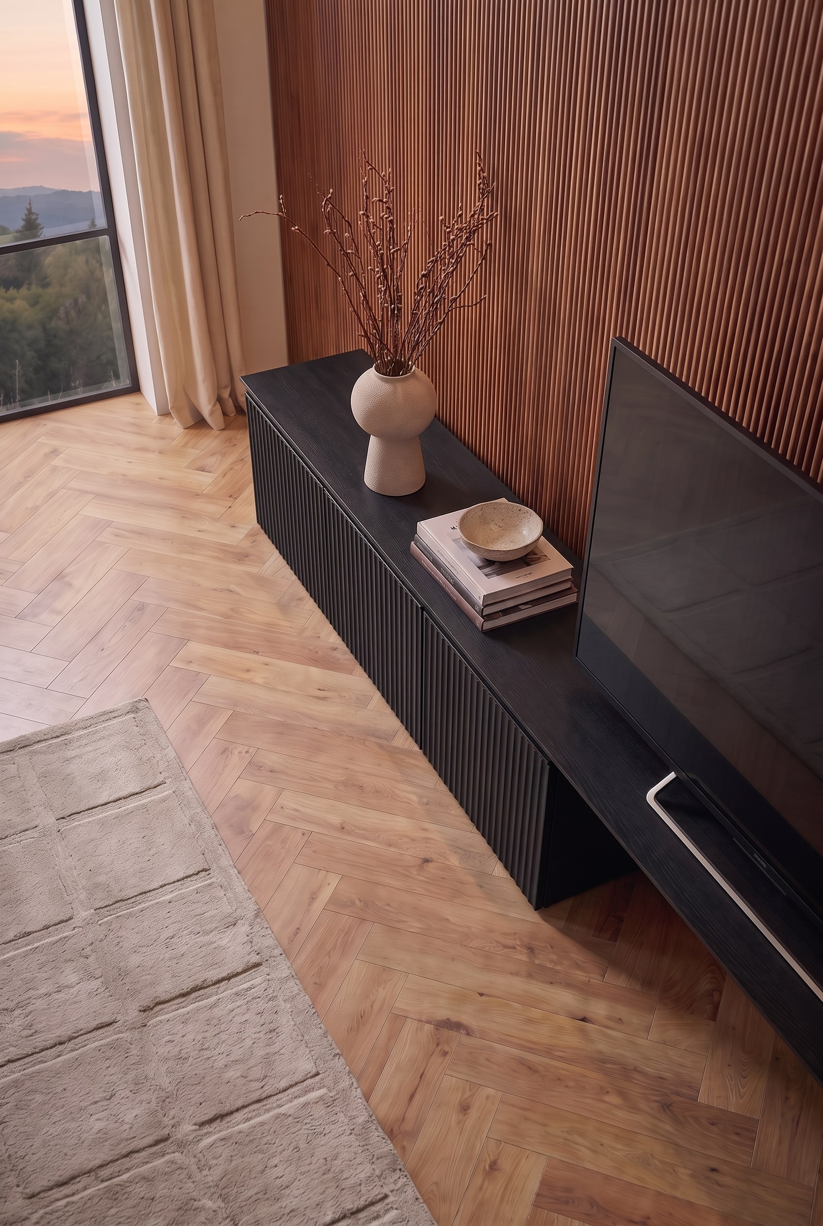 Schuine bovenaanzicht op het zwarte tv-lowboard. Boeken, een schaal en een vaas fleuren het oppervlak naast het scherm op.