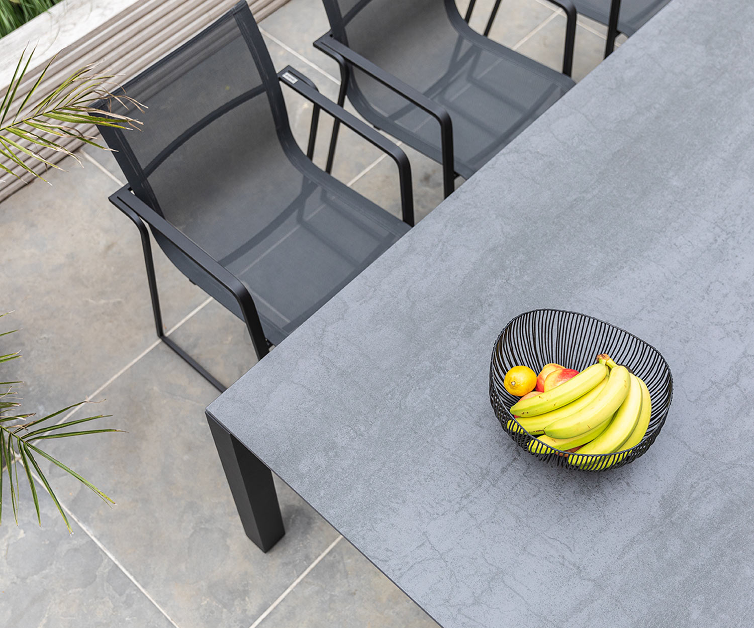 Muze Design Gartenstuhl von Oasiq im Detail von oben am Gartentisch auf Balkon Muze Design Gartenstuhl von Oasiq im Detail von oben am Gartentisch auf Balkon