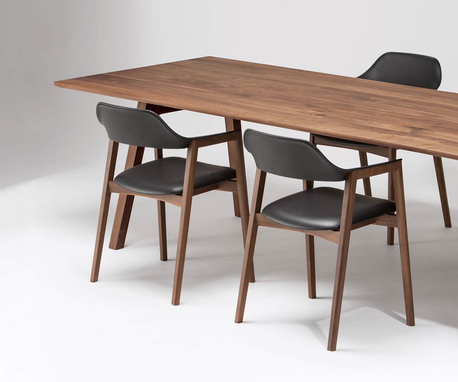Conde House Ten Design Armlehnenstuhl mit gepolstertem Sitz an einem Ten Tisch
