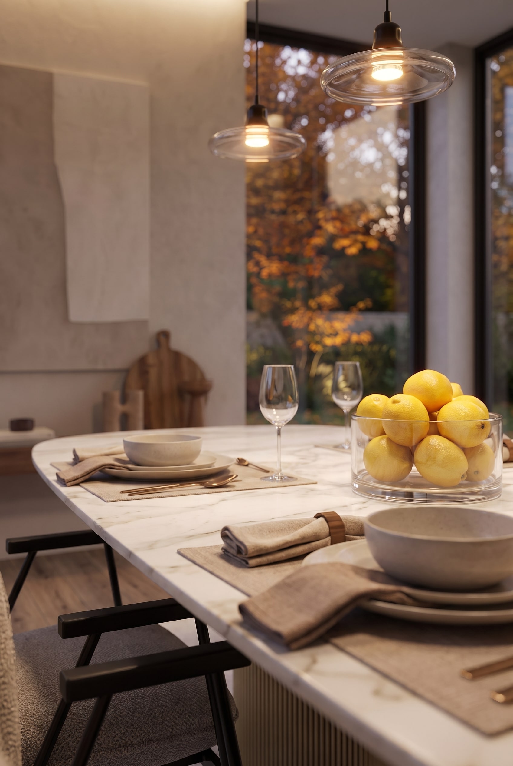 Zijdelings perspectief over de eettafel met focus op een glazen schaal vol citroenen en diep hangende glazen hanglampen.