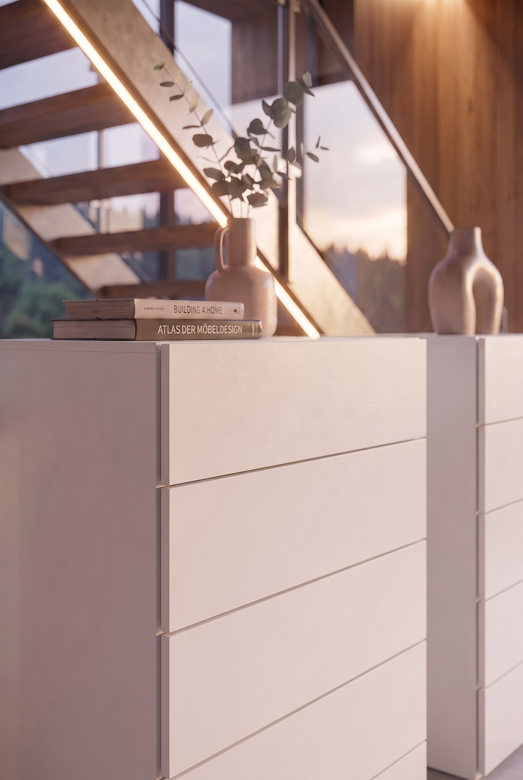 Detail van een witte ladekast met designboeken en een keramische vaas in het warme zonlicht.