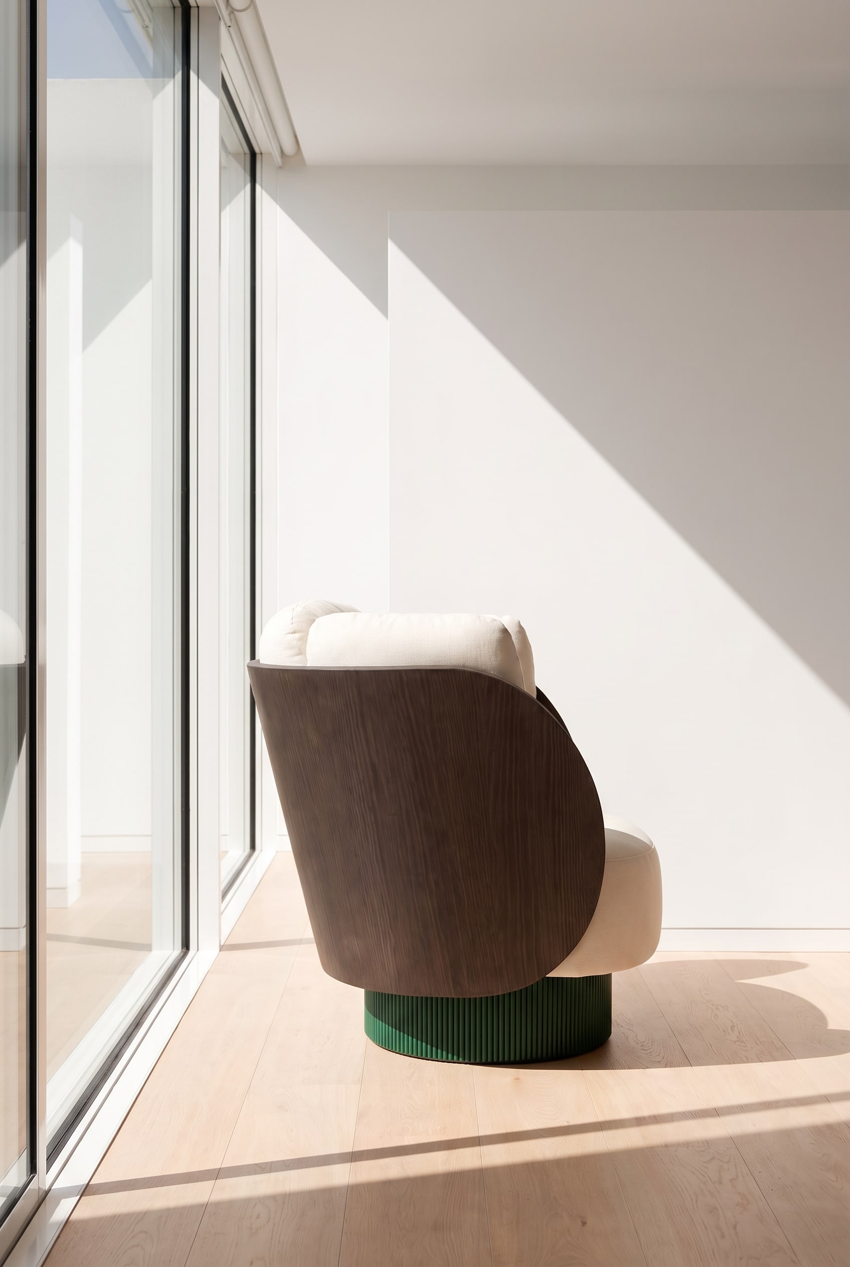 Zijaanzicht van de fauteuil, die de gebogen houten rugleuning en de volumineuze bekleding toont.