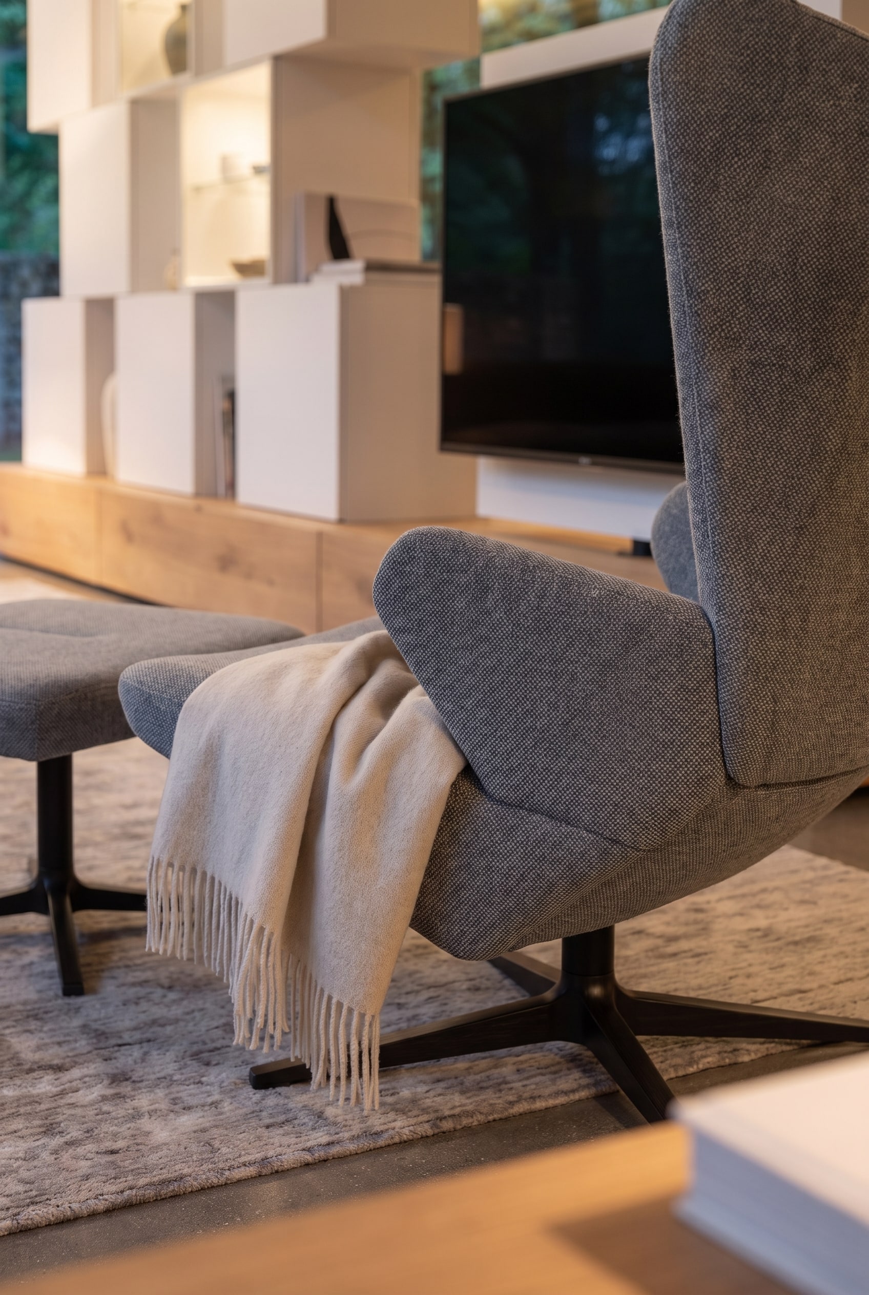Een moderne fauteuil Prostoria Trifidae staat gezellig naast een elegante roomdivider in de woonkamer