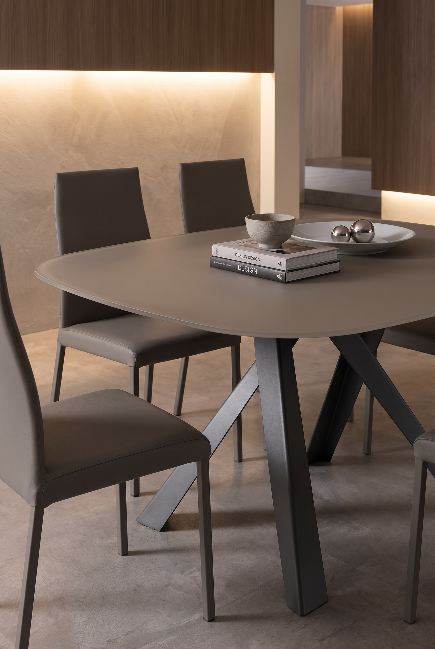 Filigree Ozzio Dining Table Bombo with a thin scratch-resistant top and elegant dining chairs in warm light