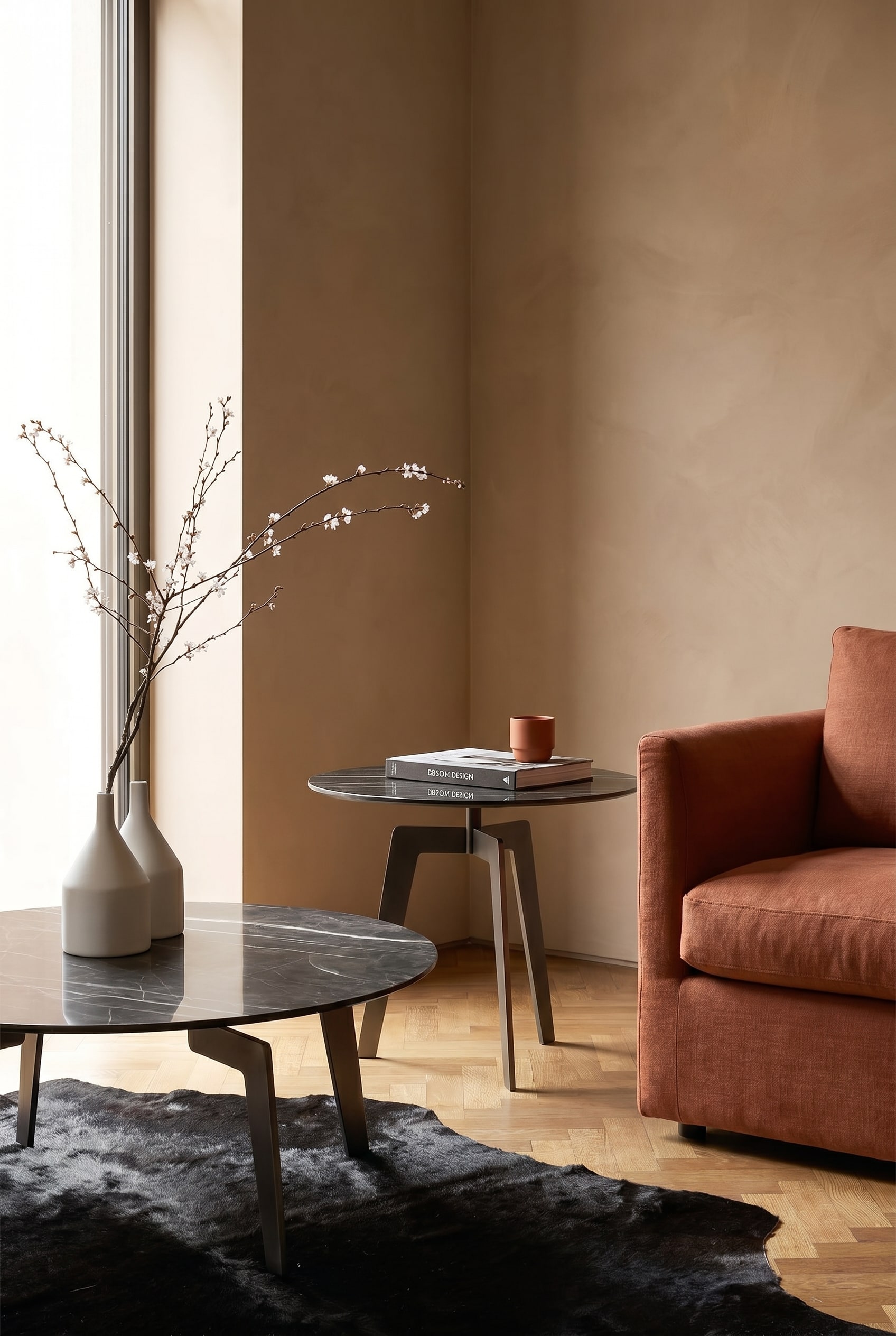 Woonkamerhoek met donkere marmeren bijzettafel naast een terracotta-kleurige fauteuil