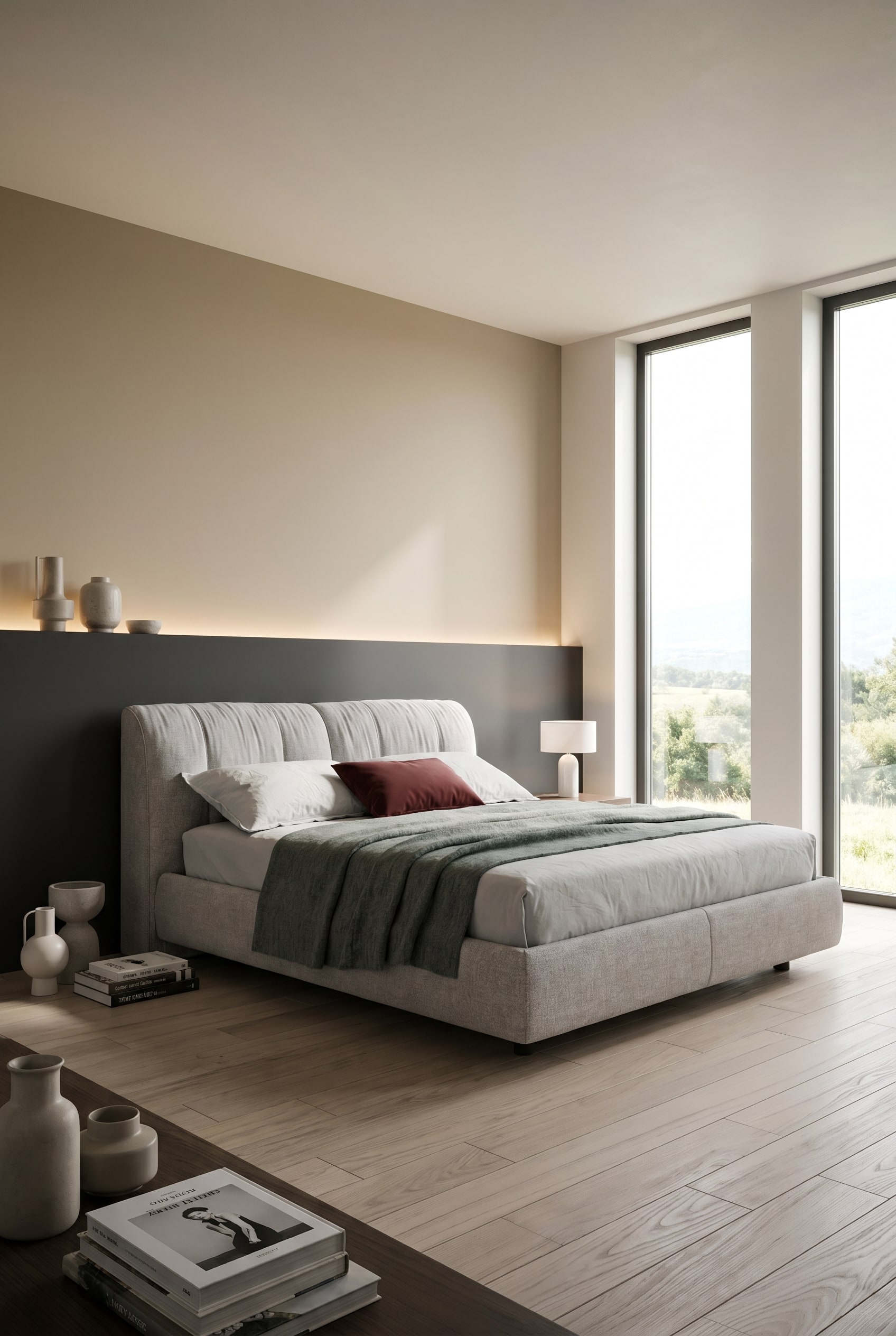 Letto imbottito grigio con contenitore davanti a una parete dipinta orizzontalmente bicolore in una camera da letto moderna