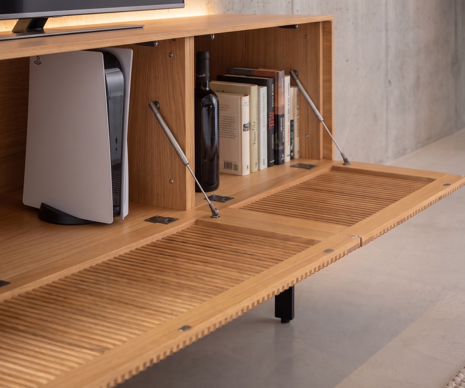 Punt Malmö Oak TV Lowboard with Slatted Drop-Down Door Punt Malmö oak TV lowboard with slatted drop-down door and interior storage for media console in a modern living room.