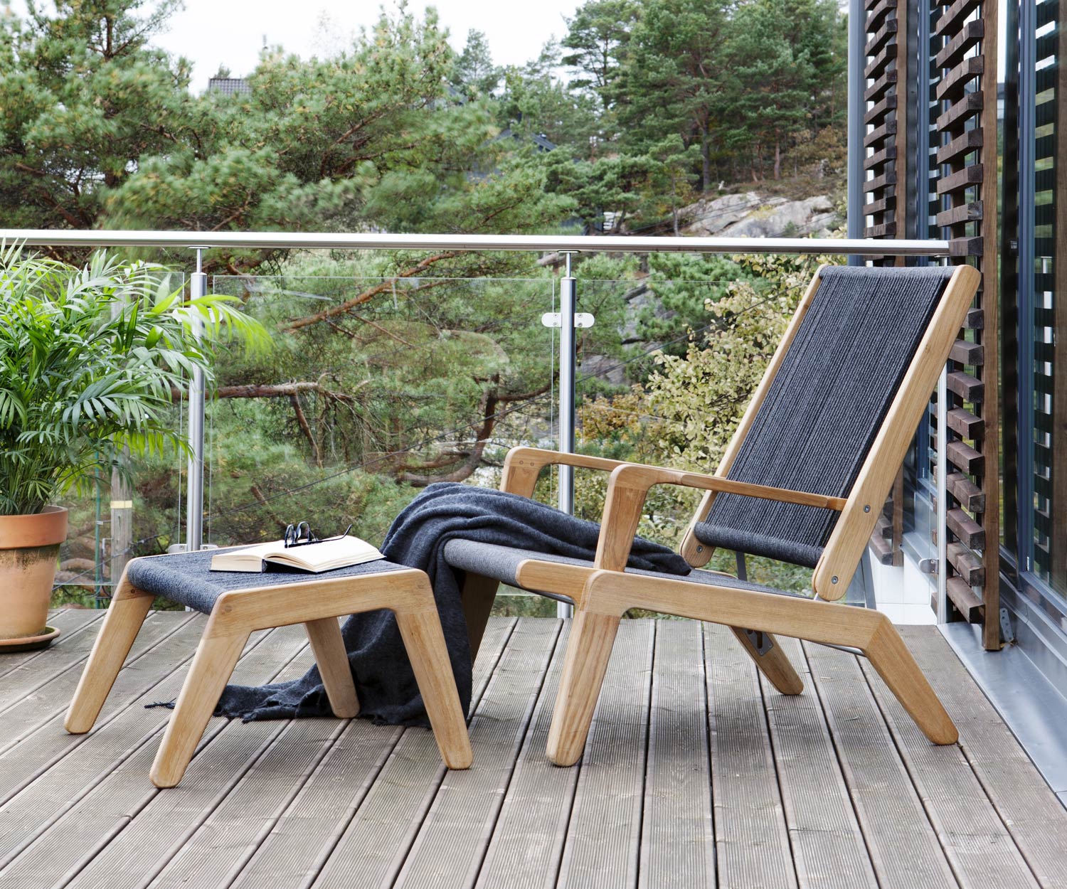 Moderner Oasiq Skagen Design Hocker aus Teak auf Balkon mit dem Skagen Liegestuhl 