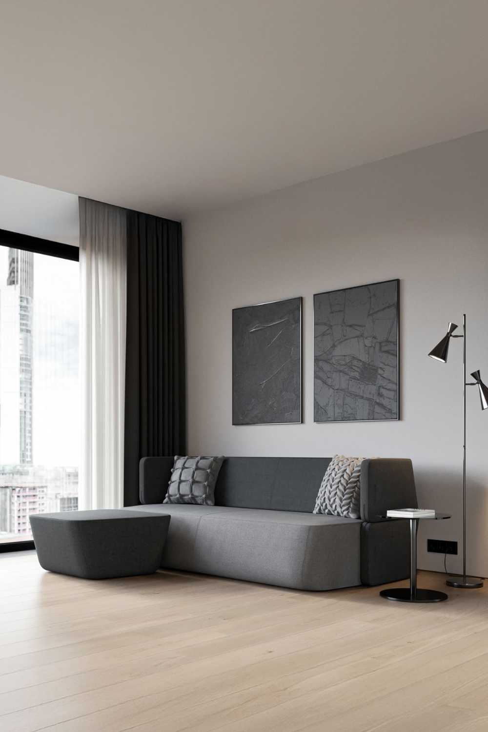 graues-schlafsofa-mit-abgerundeten-kanten-ergaenzt-durch-einen-passenden-hocker-und-einen-runden-beistelltisch
