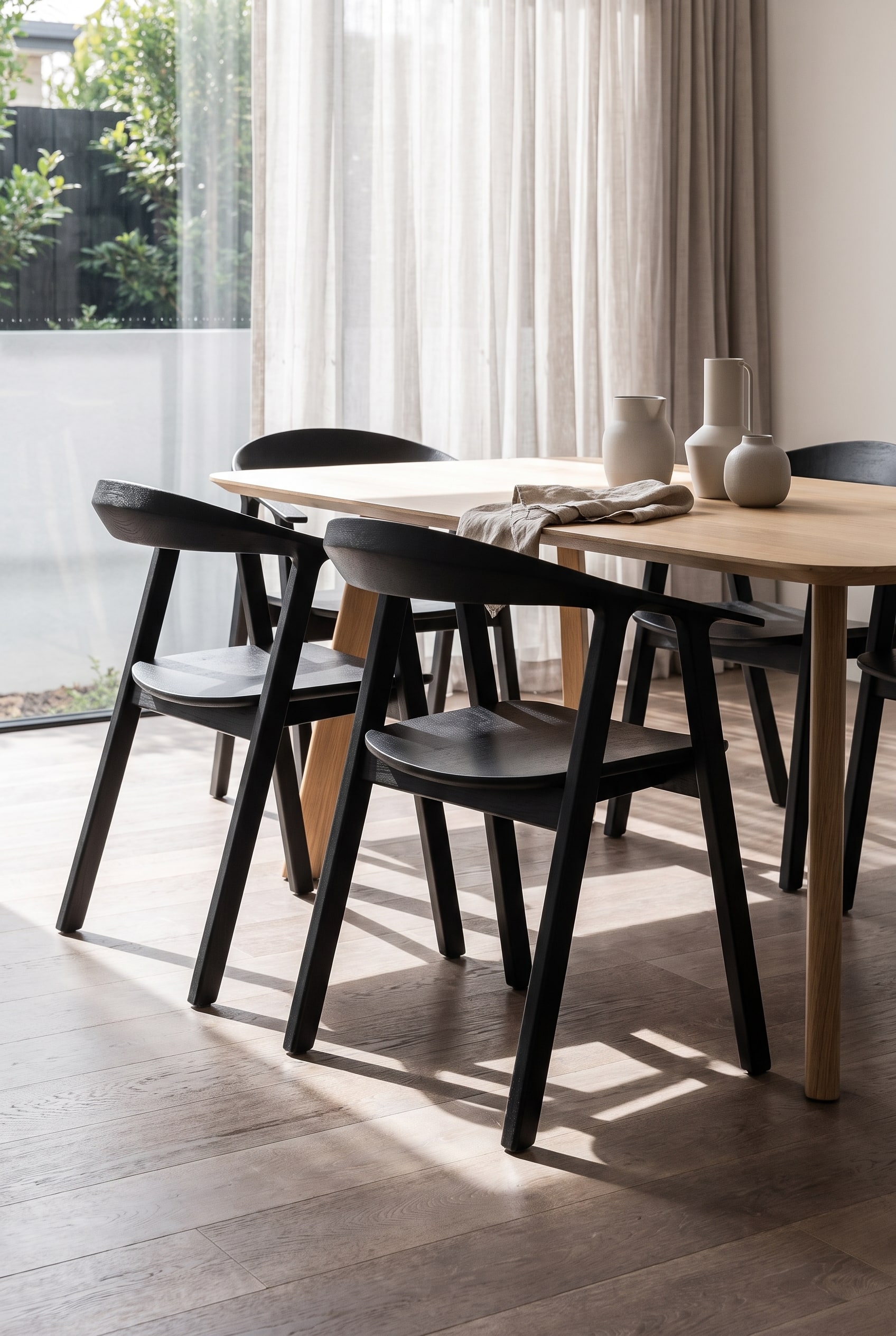Een moderne open eetruimte van achteren bekeken, waarbij stoelen met een geometrische ruitvormige rugleuning een schaduwspel creëren.