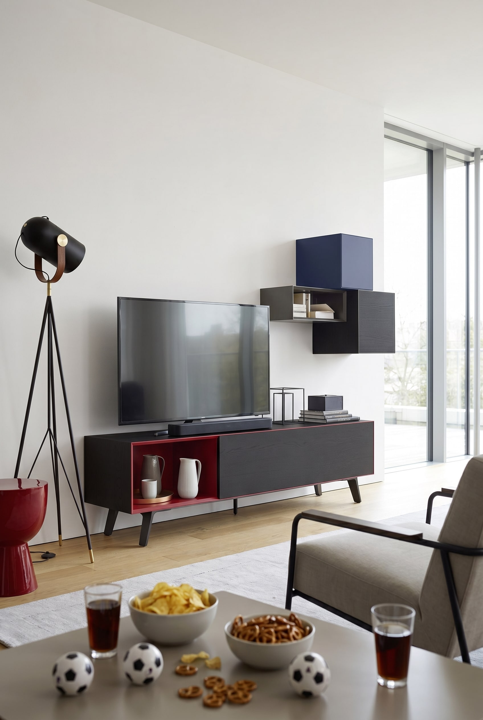 Soggiorno minimalista con lowboard bianco opaco, un grande televisore e una soundbar compatta davanti